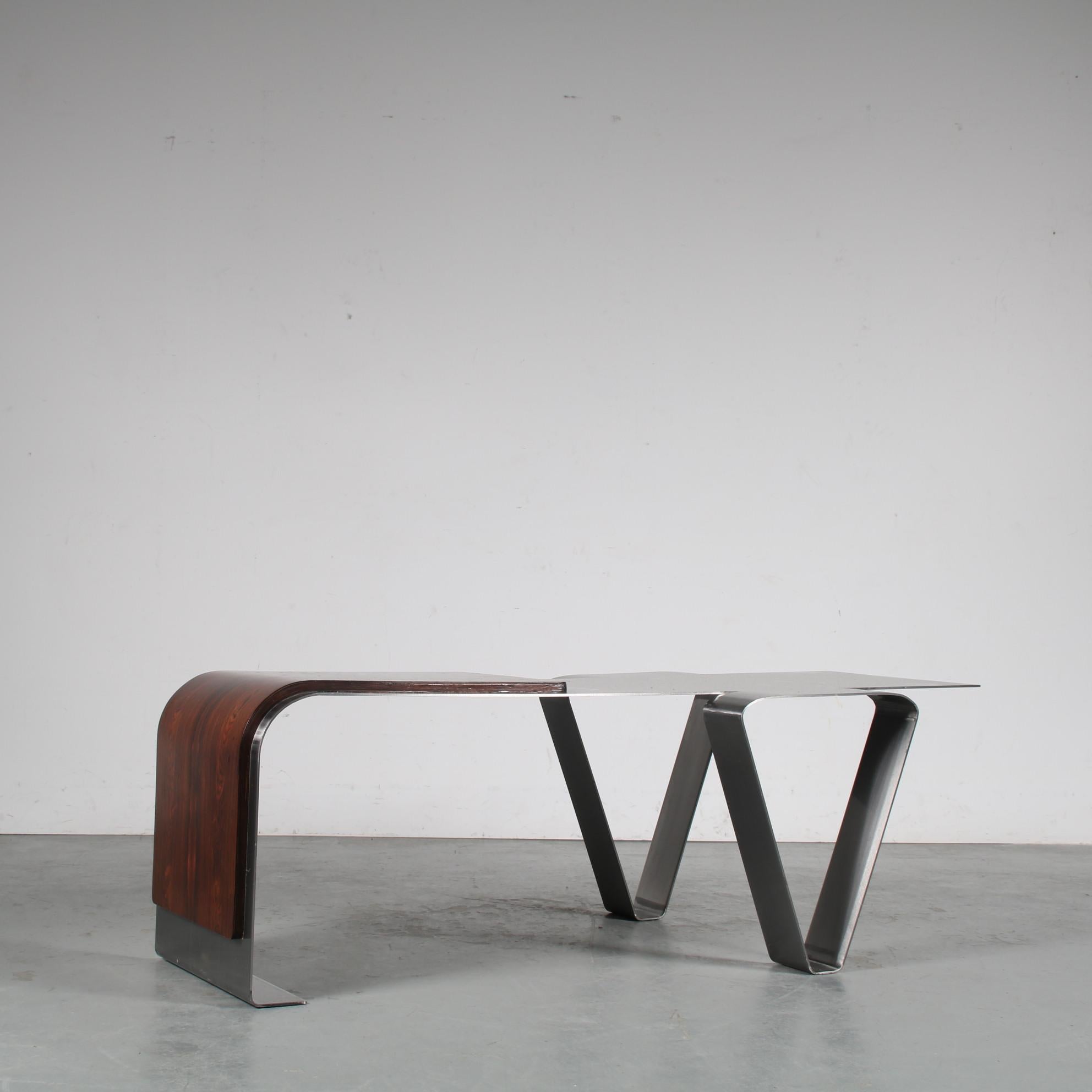 An eye-catching coffee table manufactured in France around 1970.

It is designed in the style of the pieces by Michel Boyer that were produced for the Rothschild bank. The use of stainless steel, cut and bent into a unique modern shape, gives it