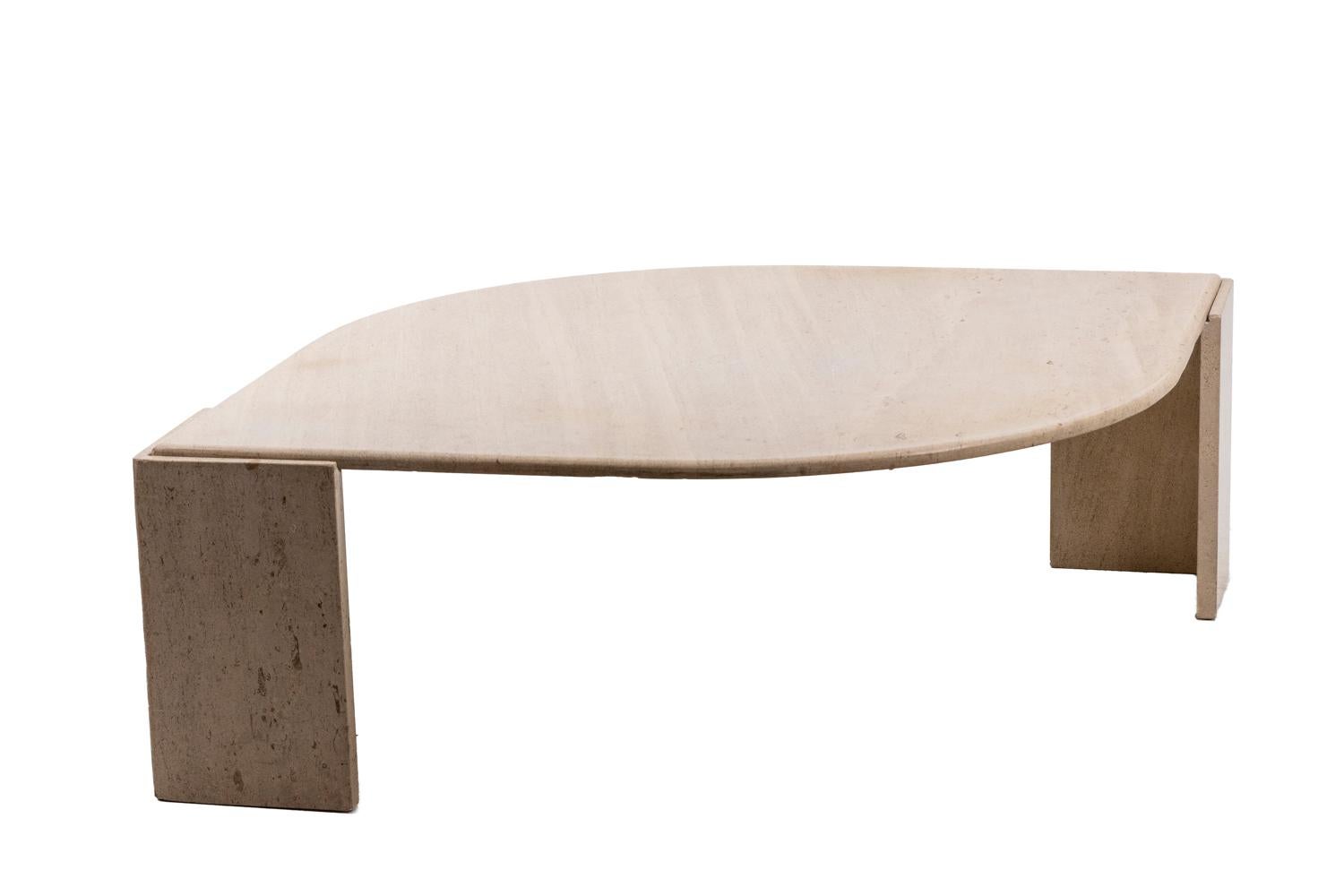 Travertine coffee table in the shape of an eye. The top comes to rest on two L shaped grooved legs.

Work realized in the 1970s.
    