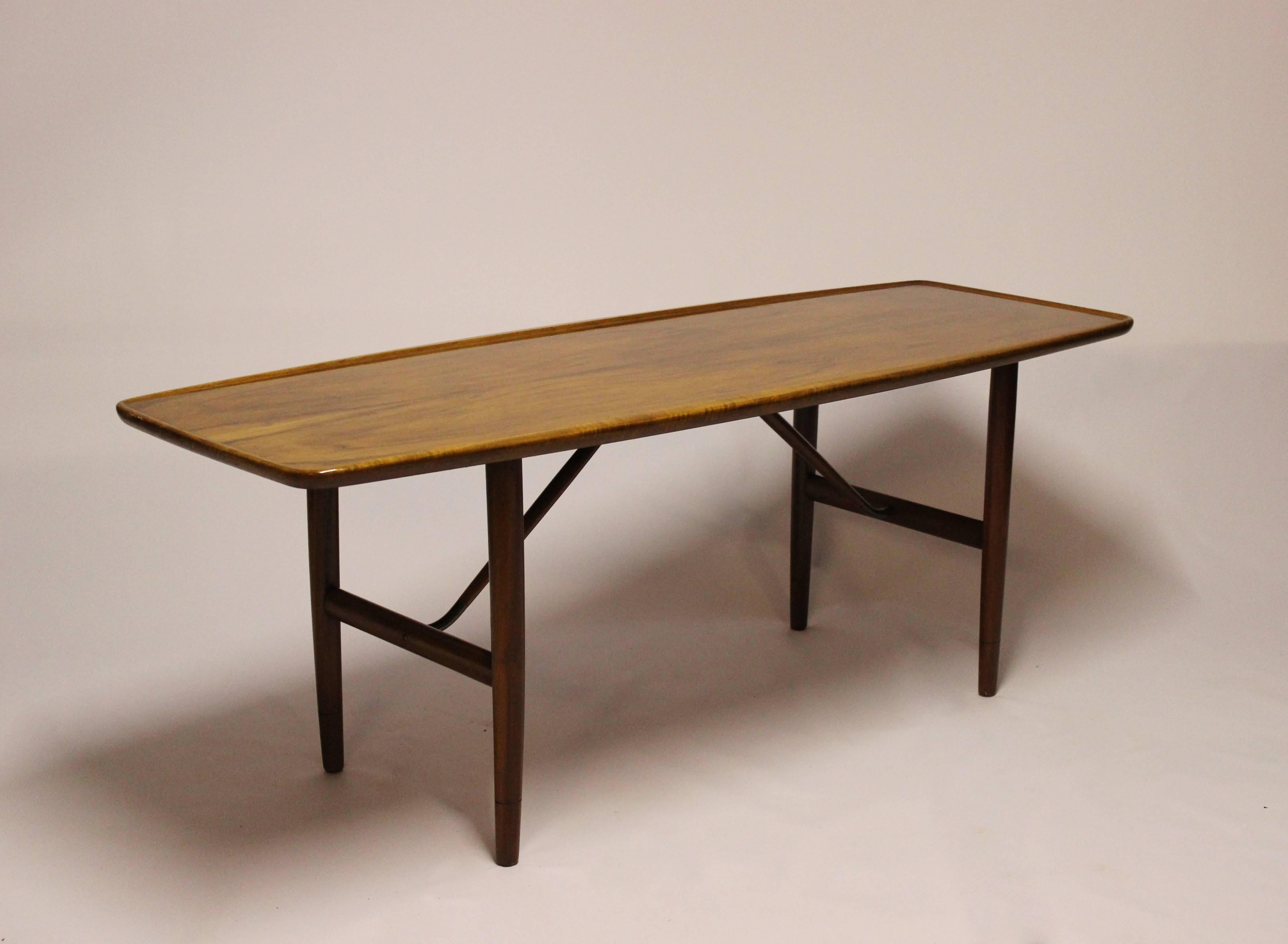 Table basse exquise en noyer, un chef-d'œuvre de design collaboratif imaginé par les célèbres Finn Juhls et Anton Kildeberg, fabriqué avec expertise dans les années 1960.

Cette table basse témoigne de la collaboration créative entre deux