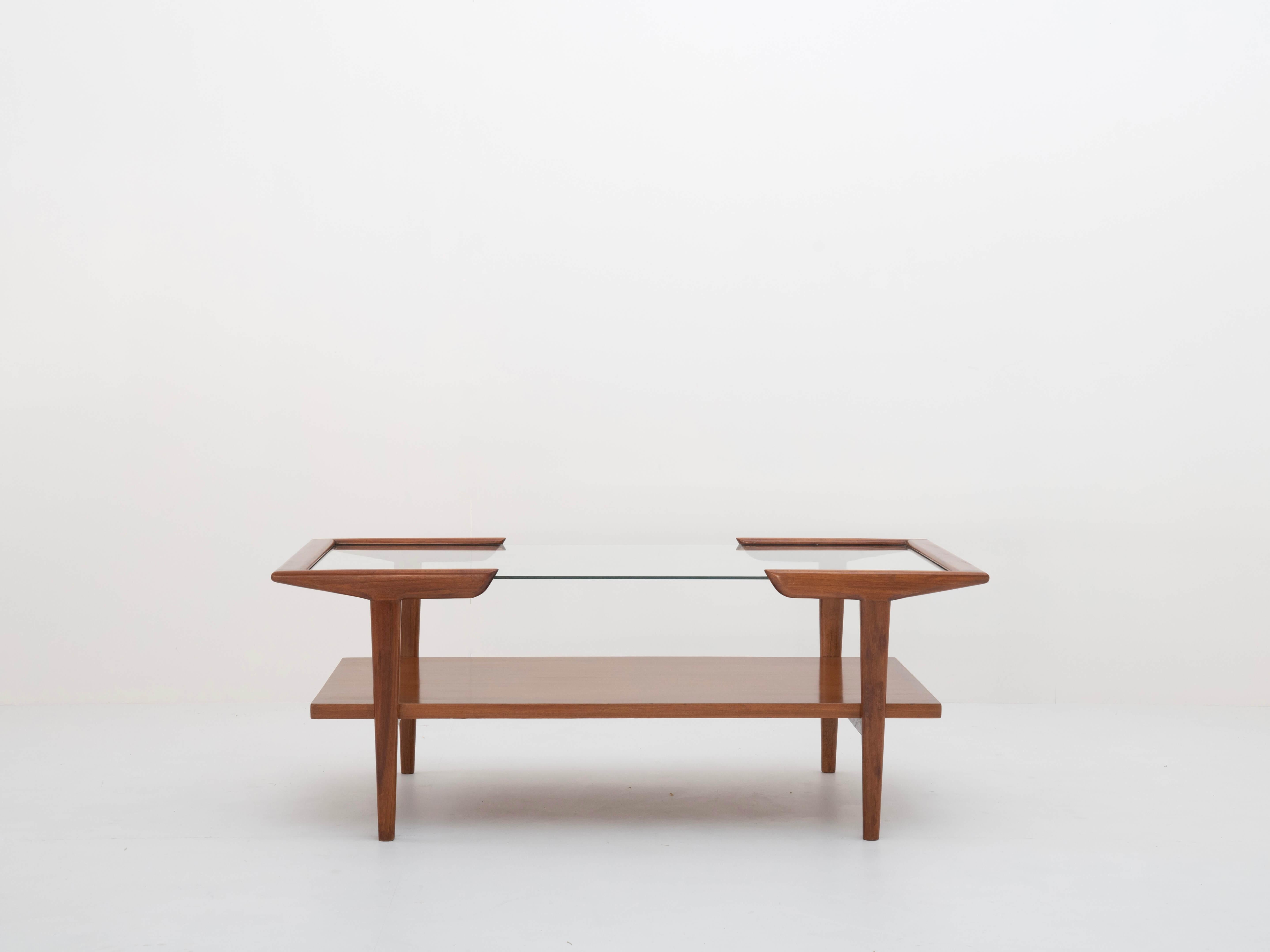 Coffee Table in wood and glass attributed to Martin Eisler, Brazil 1950s. This beautiful table is made of walnut wood and has a glass top. It has a rack under the glass top for magazines. This stylish table is clearly a statement of the mid-century