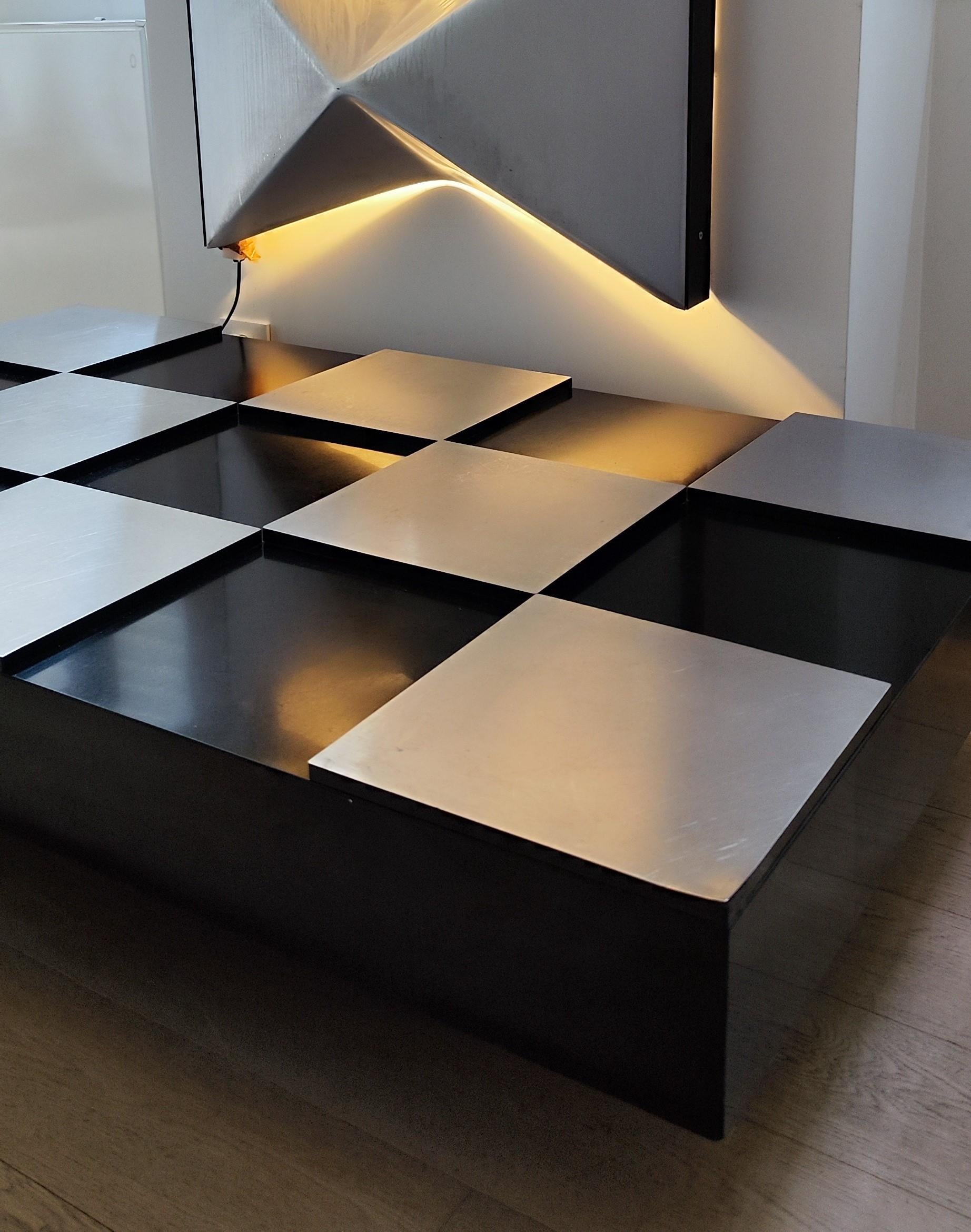 Elégante grande table basse vintage conçue par Roberto Monsani pour Acerbis dans les années 1970. 
.
Dans l'esprit des créations de Willy Rizzo. 
.
La table basse est fabriquée en stratifié de couleur noire et présente des motifs en damier en acier