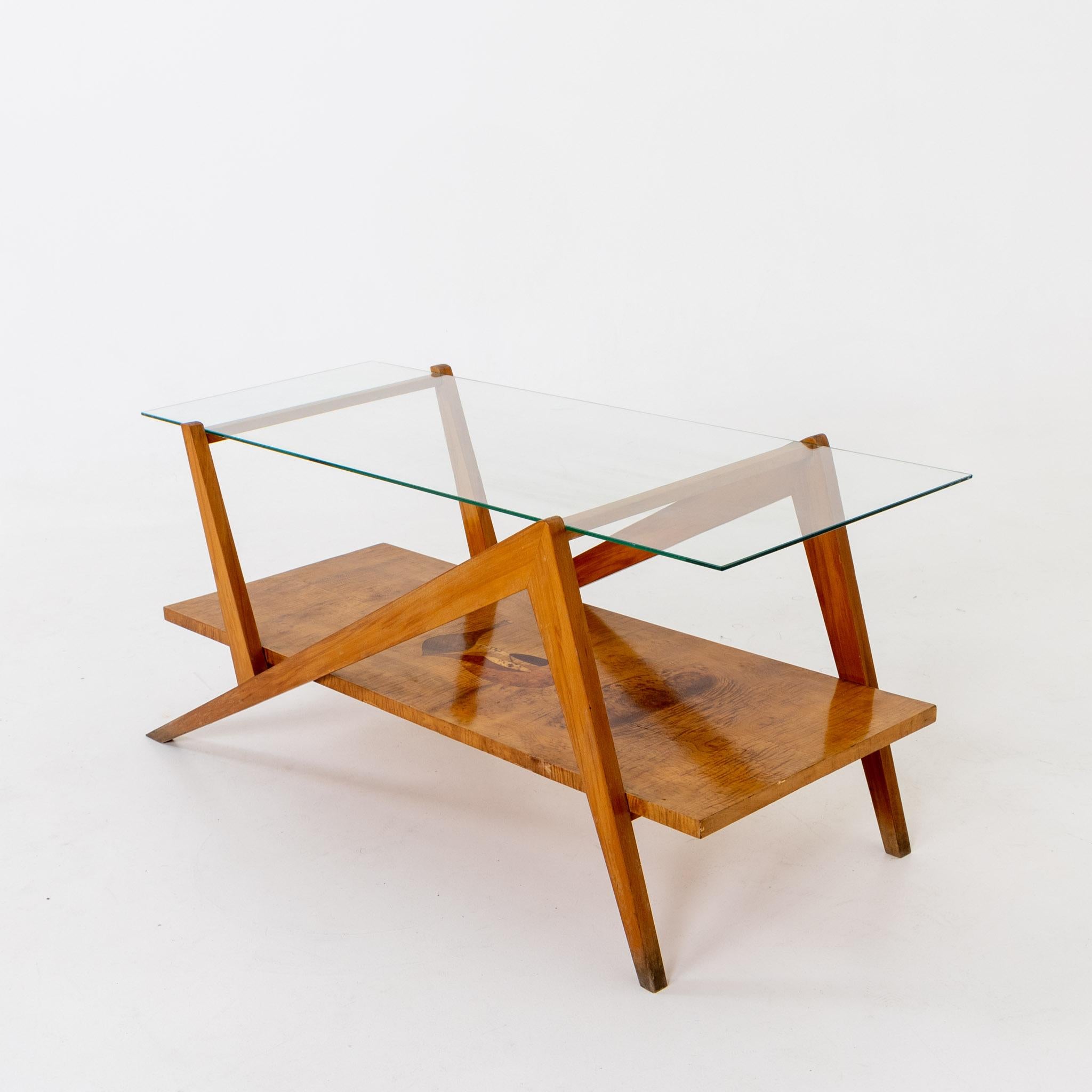 Coffee table with glass top on unusual frame with a shelf and vase-shaped inlays of various woods.