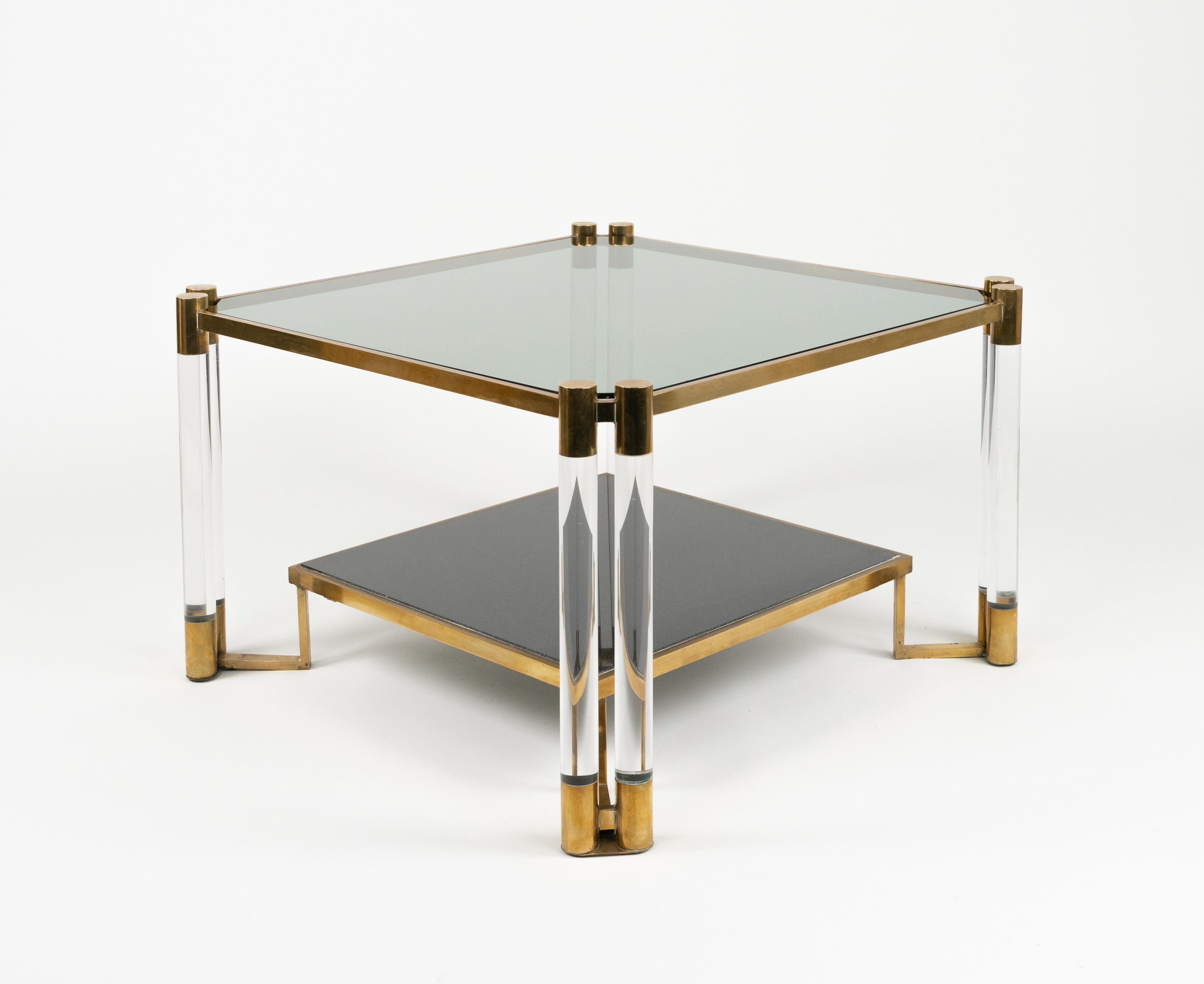 Etonnante table basse carrée du milieu du siècle à double étagère en lucite, laiton, verre fumé et céramique dans le style de Charles Hollis Jones.

Fabriqué en Italie dans les années 1970.