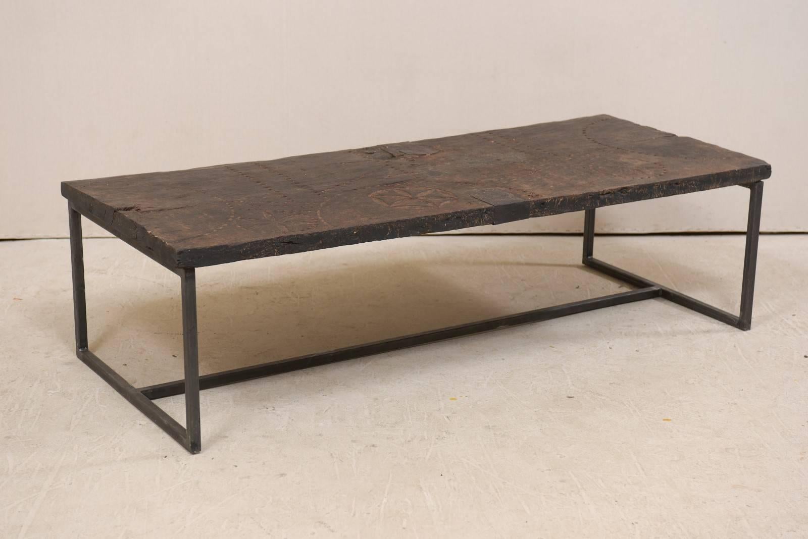 This is a custom coffee table made from an 18th century Spanish door. This unique coffee table has been fashioned from an 18th century Spanish door, with it's wonderful old patina and decorative top with floral accents and fluid lines which have