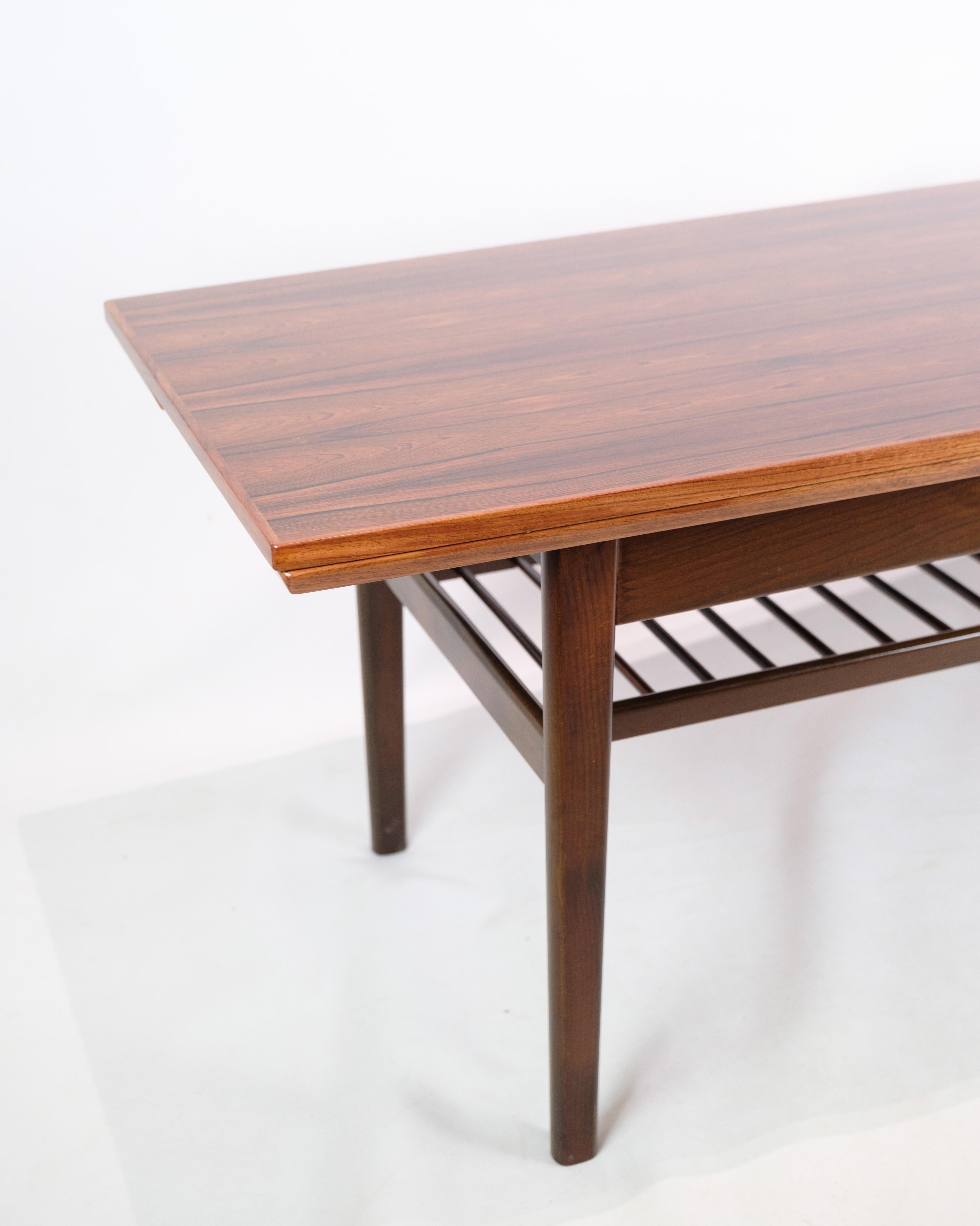 Cette table basse est une impressionnante pièce d'art mobilier qui respire à la fois l'élégance et la fonctionnalité. Fabriqué en bois de rose et conçu par le célèbre Kai Kristiansen pour Vildbjerg Møbelfabrik en 1960, il représente un point