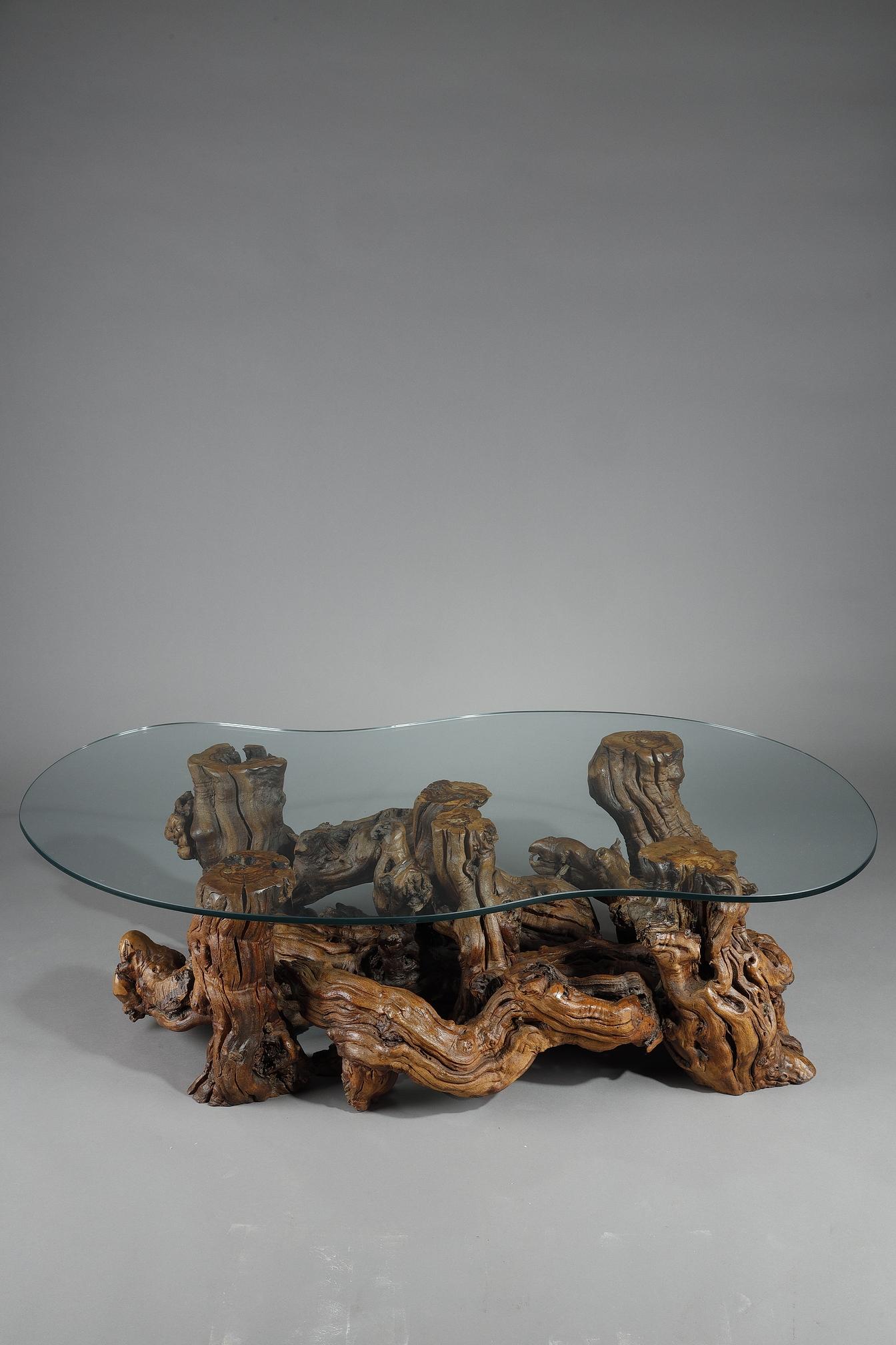 Table basse composée de racines d'arbres entrelacées avec un plateau en verre en forme de haricot. Un travail d'artiste et une pièce unique qui met en valeur le sublime travail laborieux des racines.

