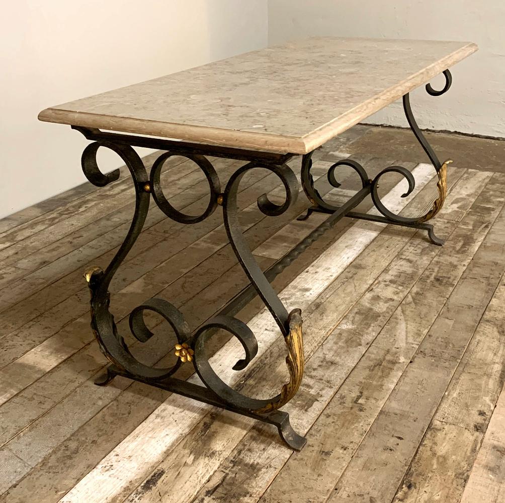 Midcentury wrought iron marble top coffee table features a graceful lyre shape on the legs which are also connected together with iron for long lasting beauty. Subtle gold highlights add visual appeal, while the luxuriously veined marble top adds