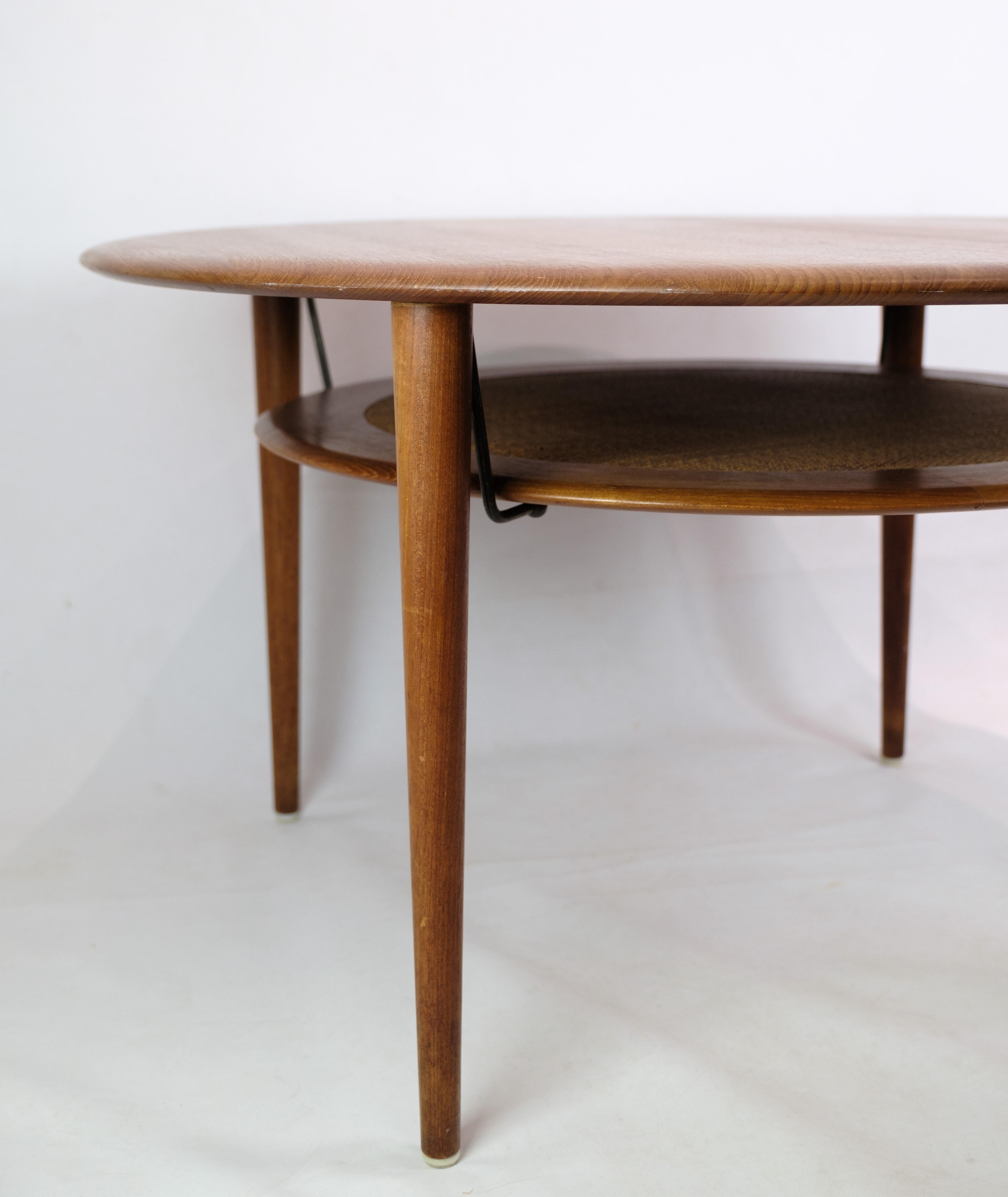 Coffee table, model FD 515, designed by Peter Hvidt 1916-1986 & Orla Mølgaard-Nielsen 1907-1993 made in teak wood from 1956. The coffee table is fitted with a wicker newspaper shelf and brass fittings. Made by the manufacturer France. 