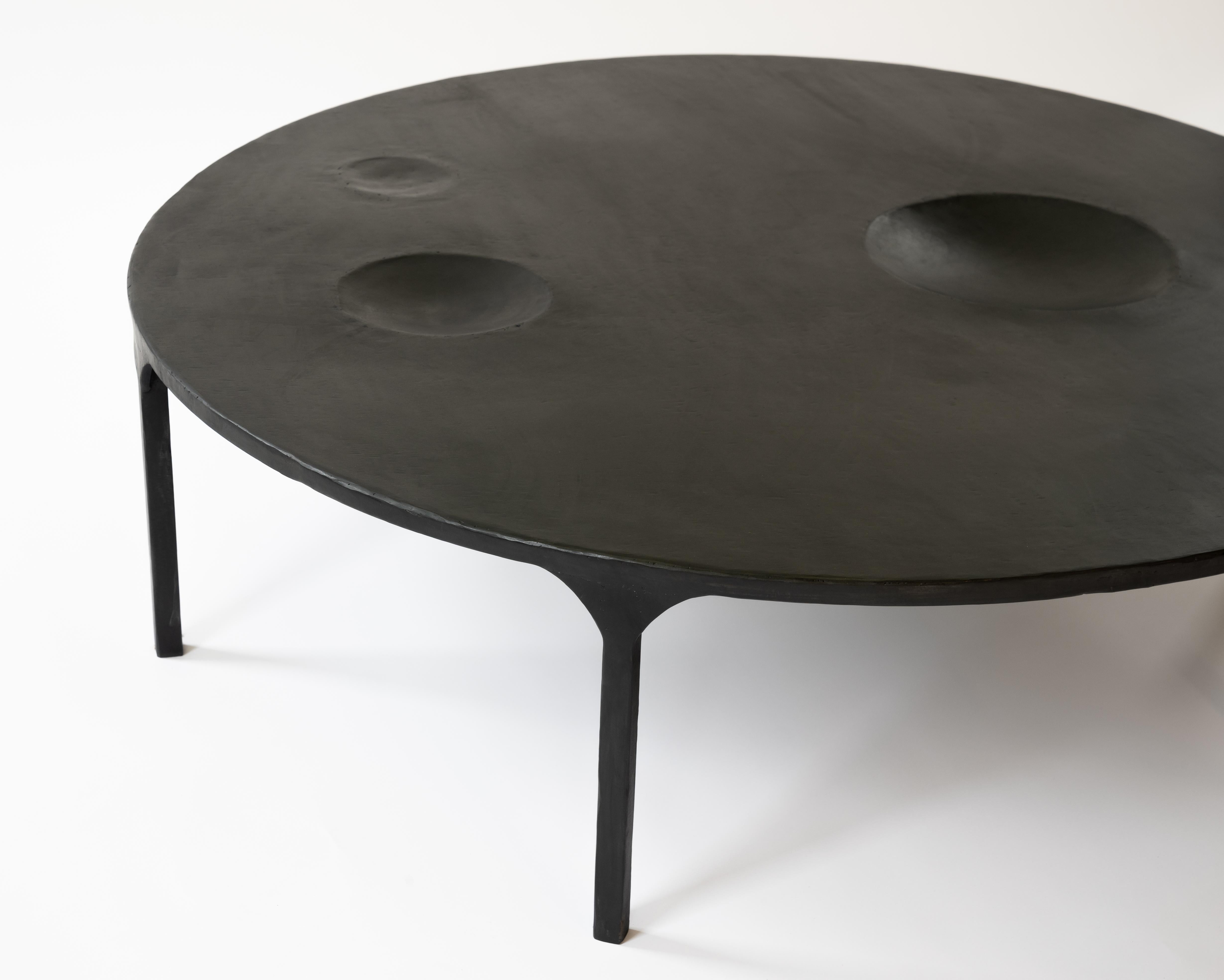 TABLE NO. 11 - Round
J.M. Szymanski
d. 2021

Handmade entirely out of blackened and waxed steel, this table features geometric
voids within the table itself. Also available with food-safe, ceramic, bowl inserts. Each
one is made specifically