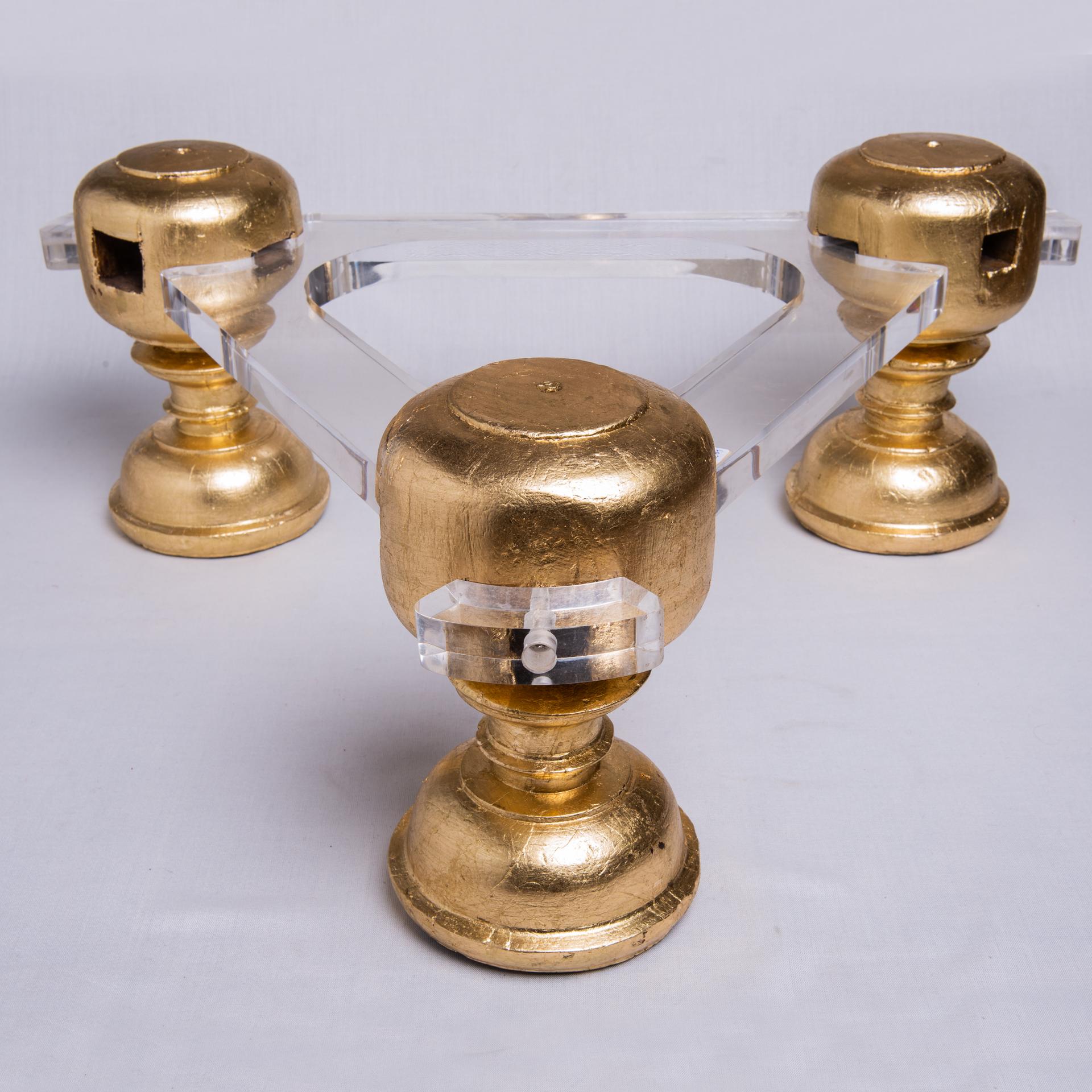 Base pour table basse avec trois bases de sculptures rondes antiques en bois doré, reliées par du plexi pour un style moderne. Porte un plateau rond en verre.
  