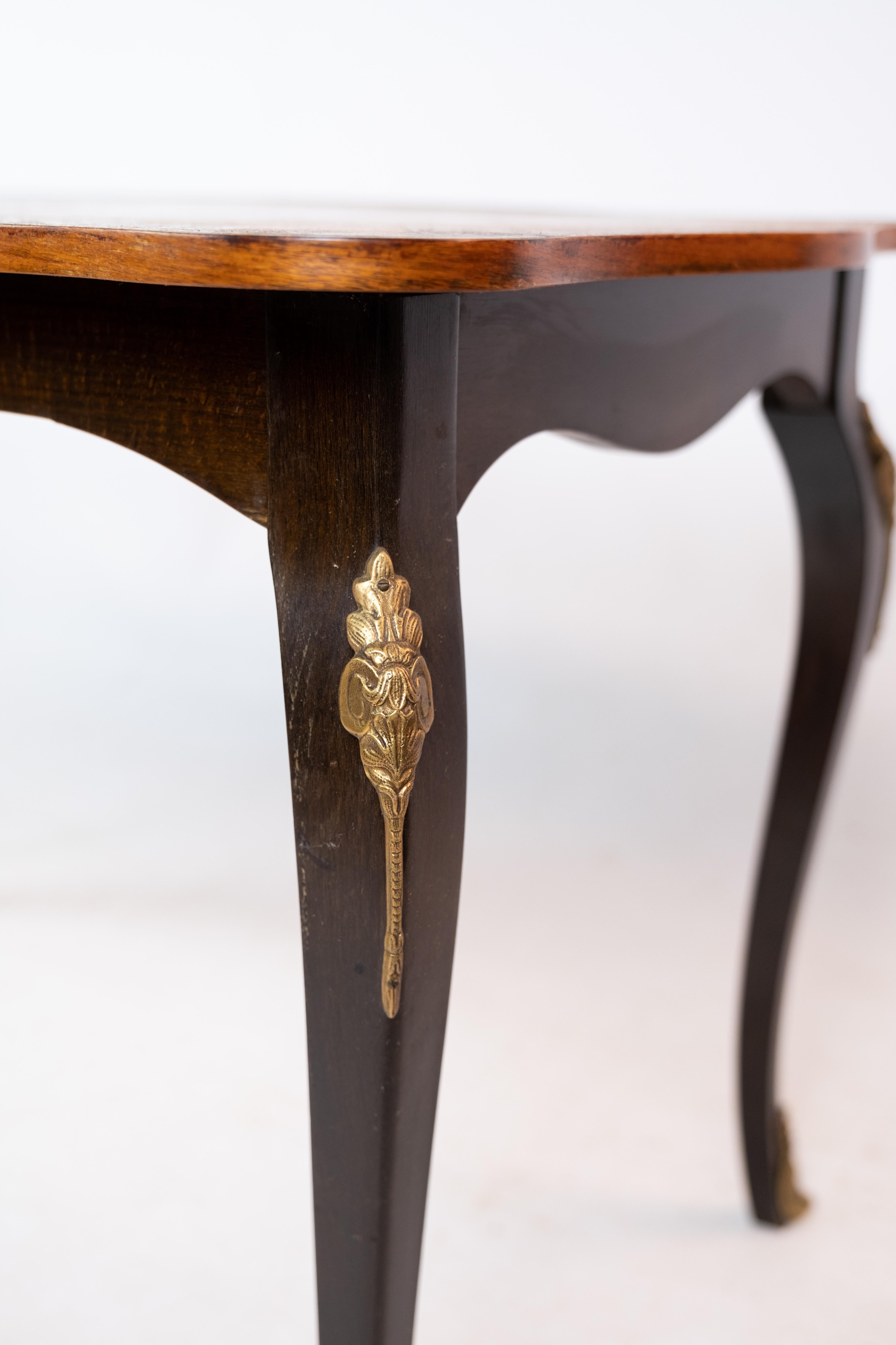 Antique rococo style coffee table with stained wood legs with brass decoration and surface in rosewood with intarsia from around the 1930s.

This product will be inspected thoroughly at our professional workshop by our educated employees, who