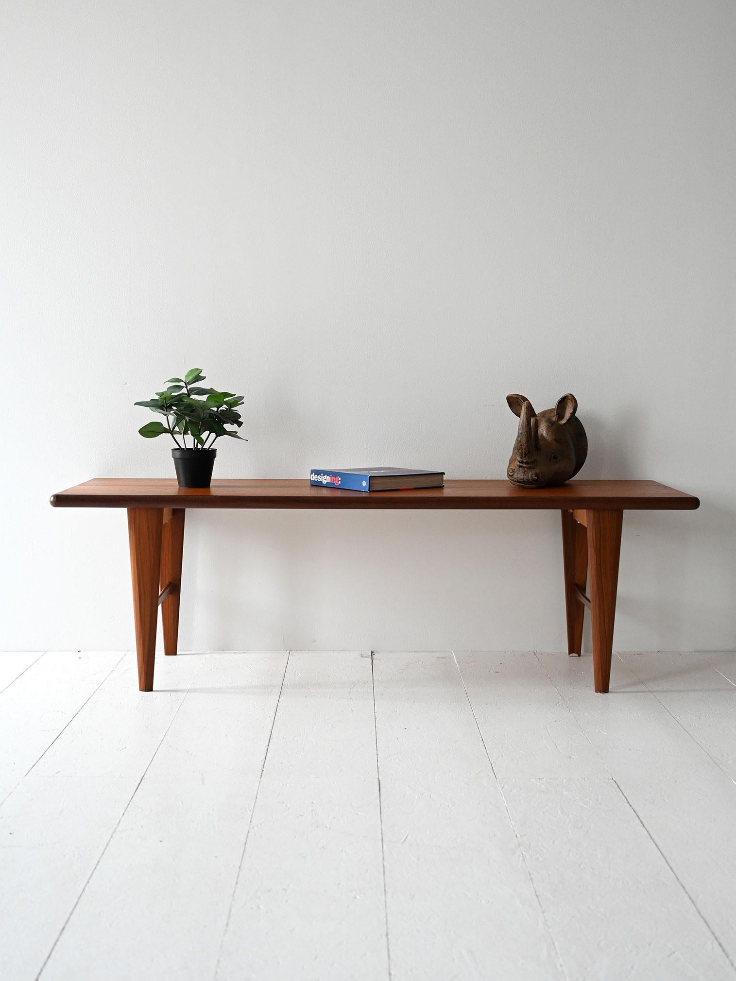 Mesa de centro de teca de los años 50/60 de perfil ligero y patas cónicas .

Mesa de centro vintage escandinava de teca de los años 50/60, con tablero rectangular de bordes suaves y patas cónicas unidas por un elemento central de refuerzo. Su diseño