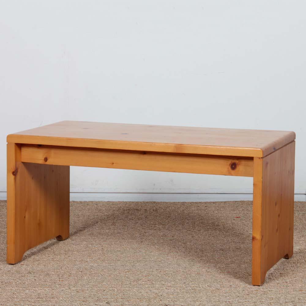 This solid pine coffee table dates from the 1960s. It was one of the models selected by Charlotte Perriand for the Les Arcs ski resort. It features a solid top with slightly smoothed edges resting on two side panels, providing a sturdy, stable