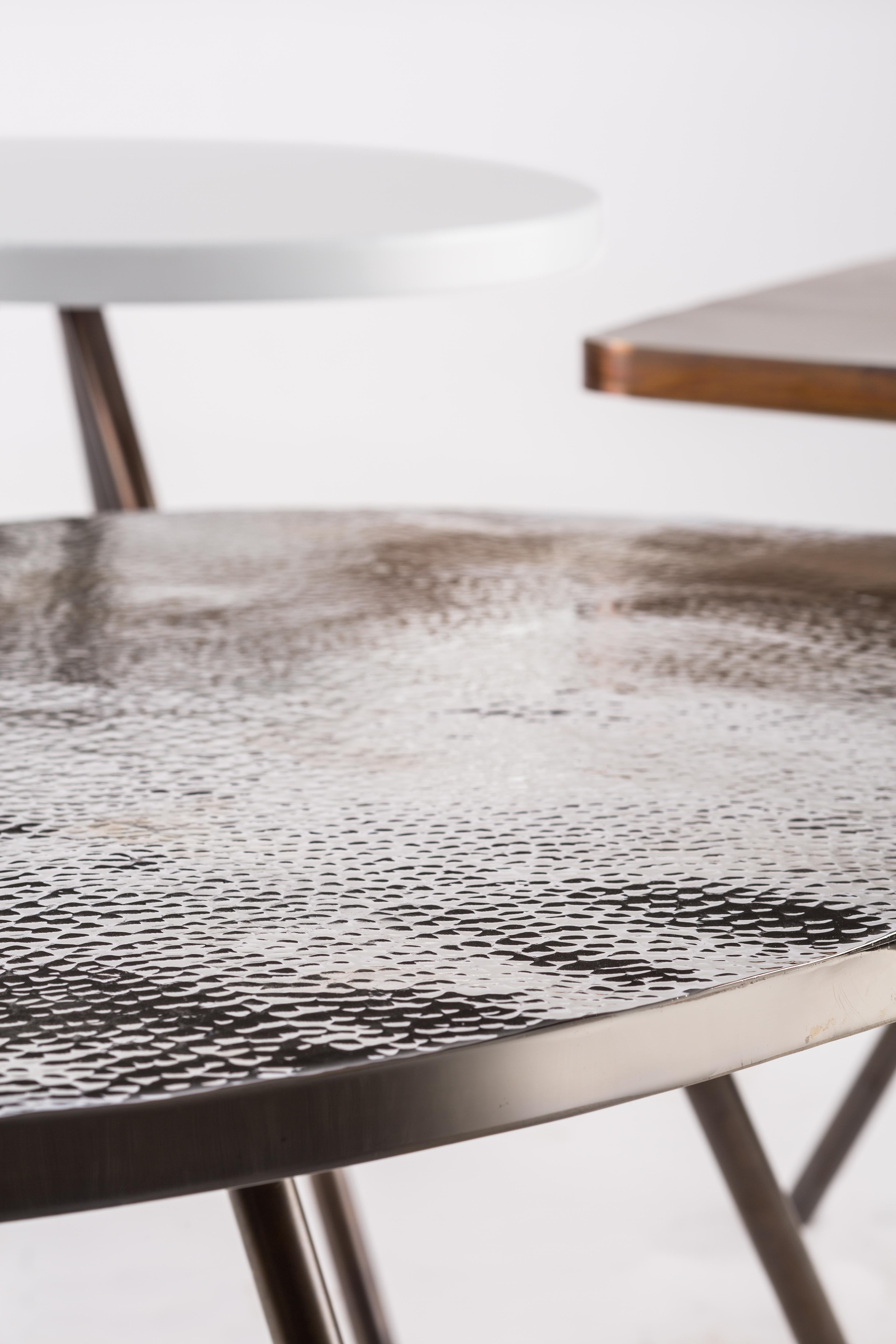 Coffee Table Set of 3 with Hammered Brass, Nickel and Electrostatic Tops. 
Our Trio tables will bring more than coziness to your living area, thanks to their hip and original design. This coffee table is a canvas of tables designed using different