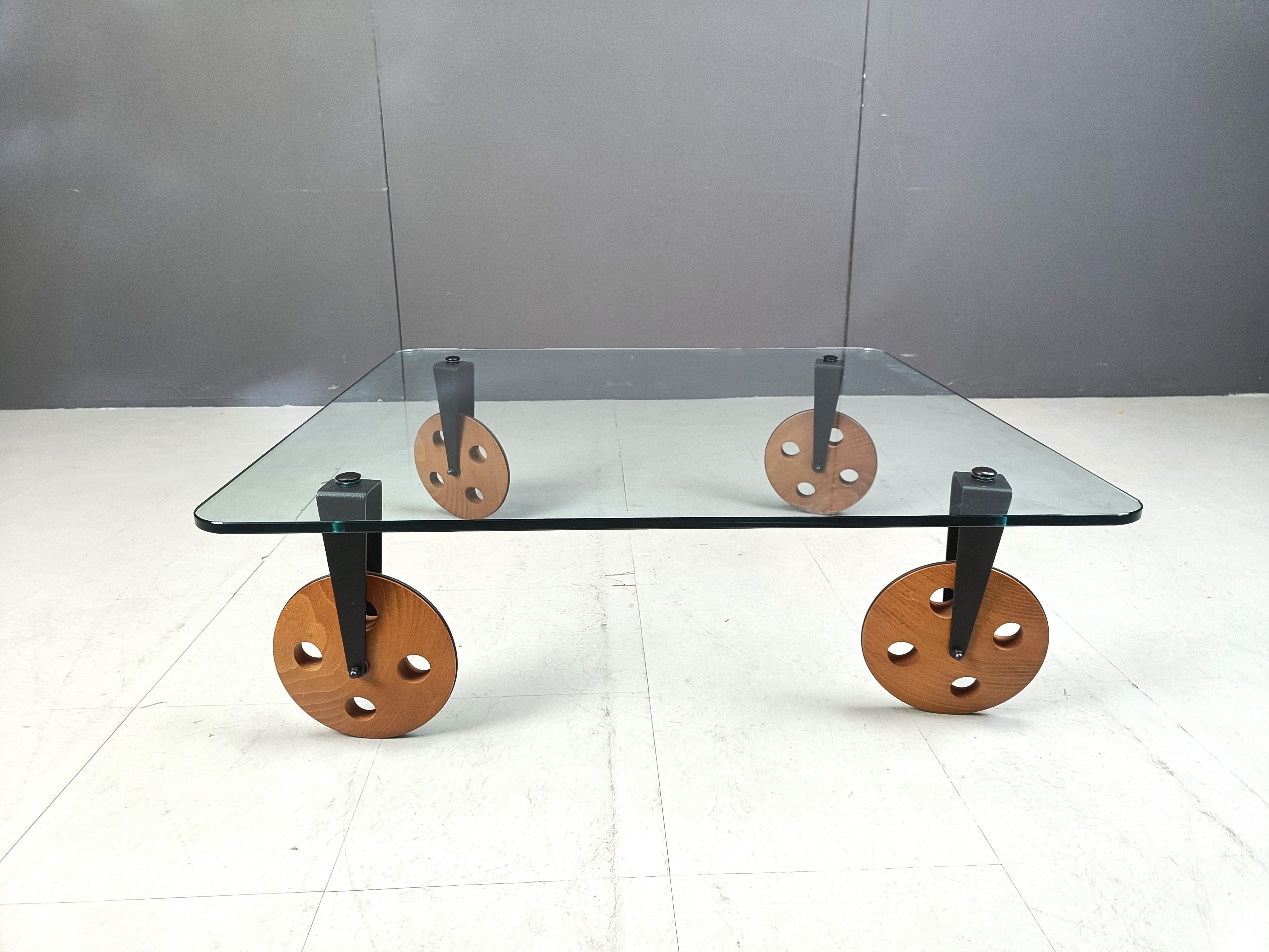 Timeless design coffee table named 'Tavolo con Ruote' which doesnt need a translation.

Made out of thick clear tempered glass with walnut wooden wheels and black steel.

Very practical design.

1960s - Italy

Dimensions
Height: 31cm
Width x depth: