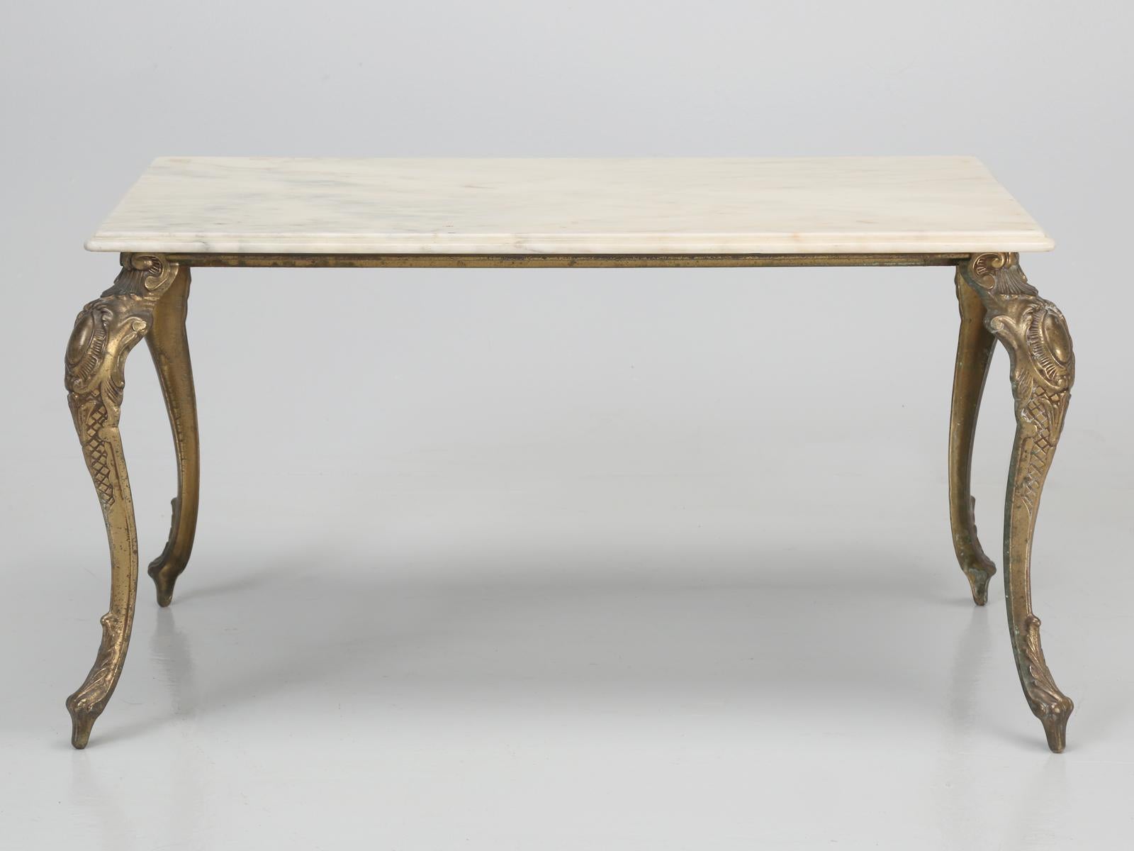 Coffee table from France, made during the 1960s or 1970s in brass, with a marble top. The marble for top of this vintage French coffee table, does appear to be coated with a layer of polyurethane, which does have an abundance of surface scratches,