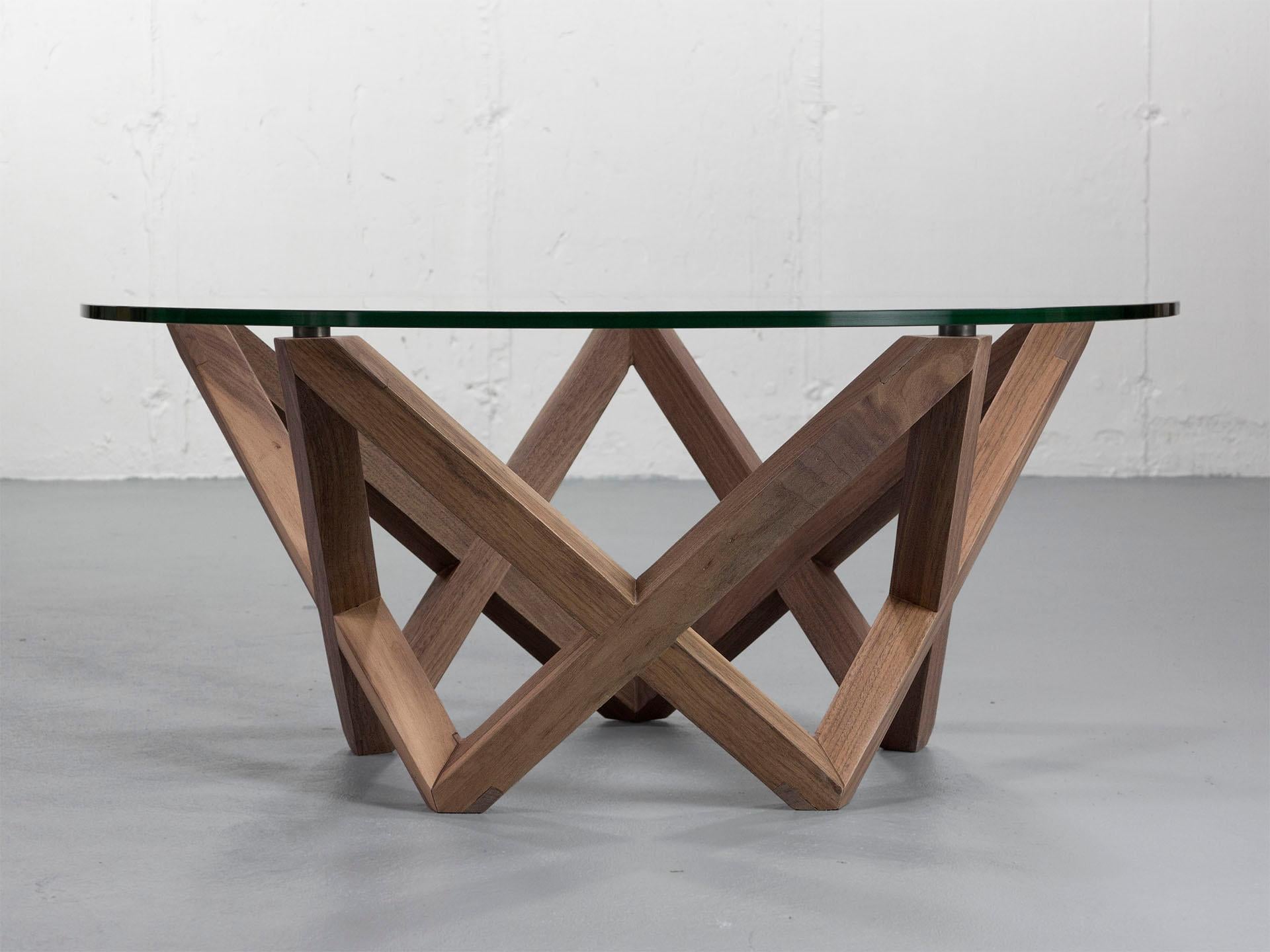 The Star Coffee Table features a round glass top suspended above a five-point star made of solid black walnut. The interlocking legs seamlessly flow around the table’s perimeter and are assembled using intricately hand-cut joinery techniques. This