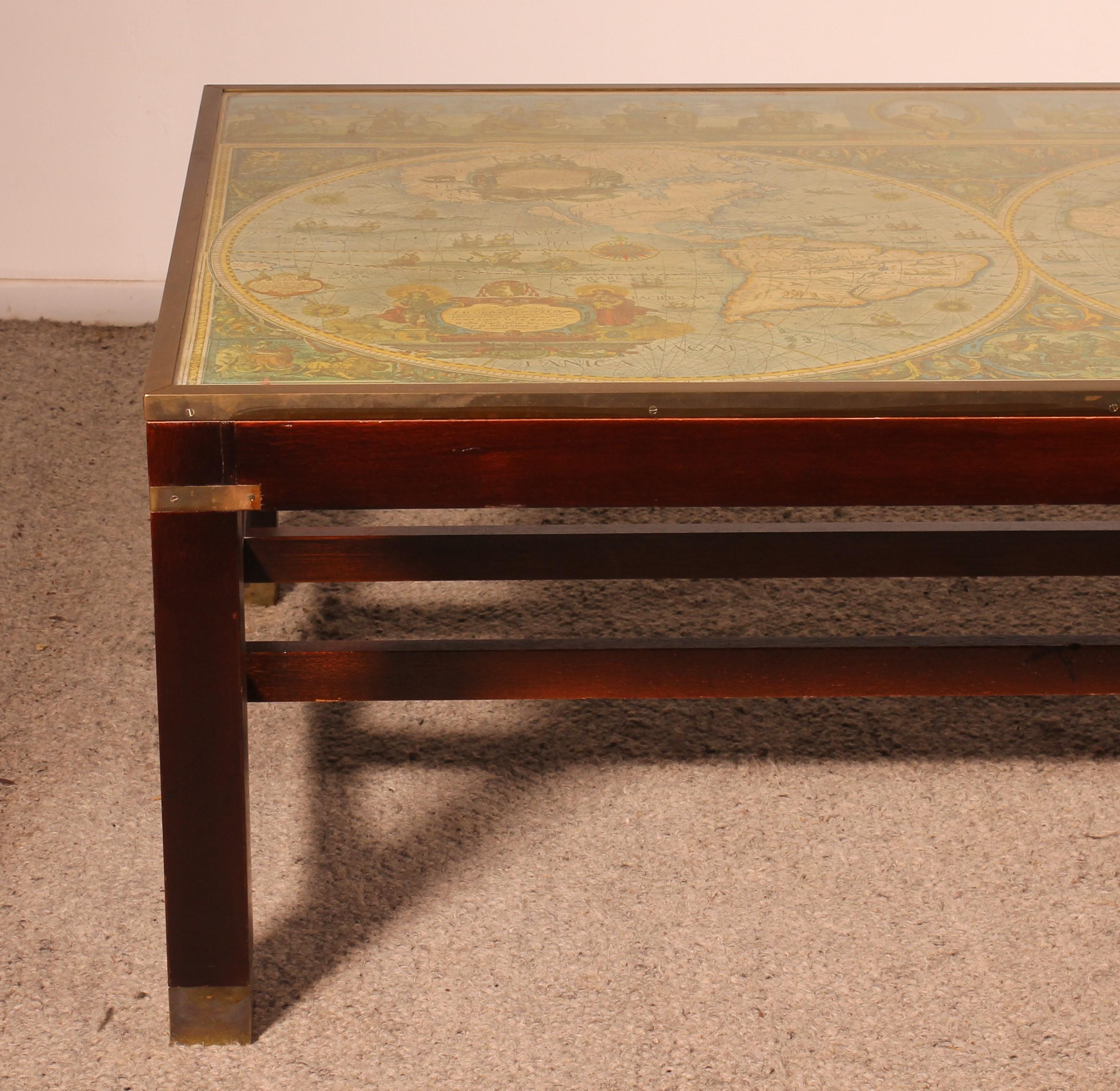 lovely coffee table from the 50s with a large 17th century world map
beautiful mahogany base with brass decorations in the spirit of marine and campaign furniture.
The top has a large glass and underneath is a representation of a 17th century