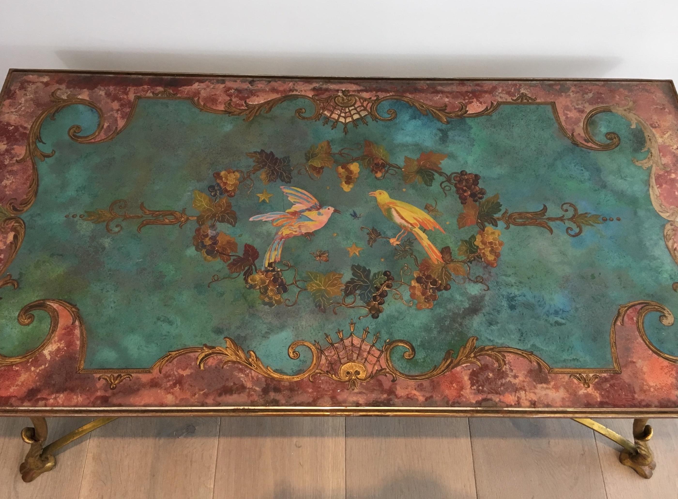 This beautiful and unique coffee table is made of a delicate gold gilt iron base with claw feet with a beautiful painting on Lucite top representing birds and flowers. French work, circa 1960.