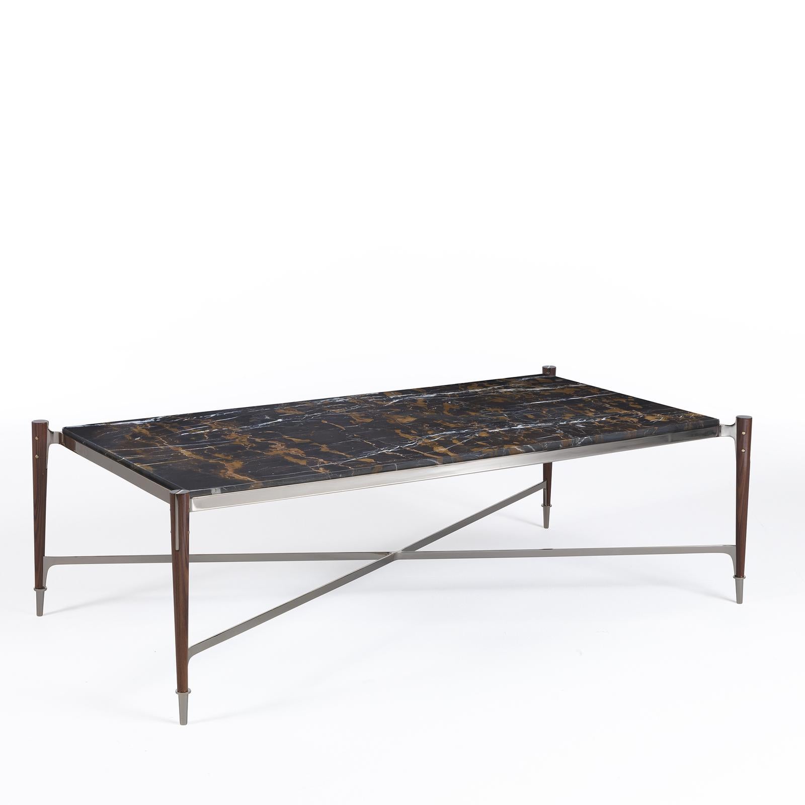 Meticulously designed by expert craftsmen, this table is characterized by balanced forms and prized materials. Fashioned of black and gold marble, the bold rectangular top is encased in an iron rim and supported by tapered legs in solid dark