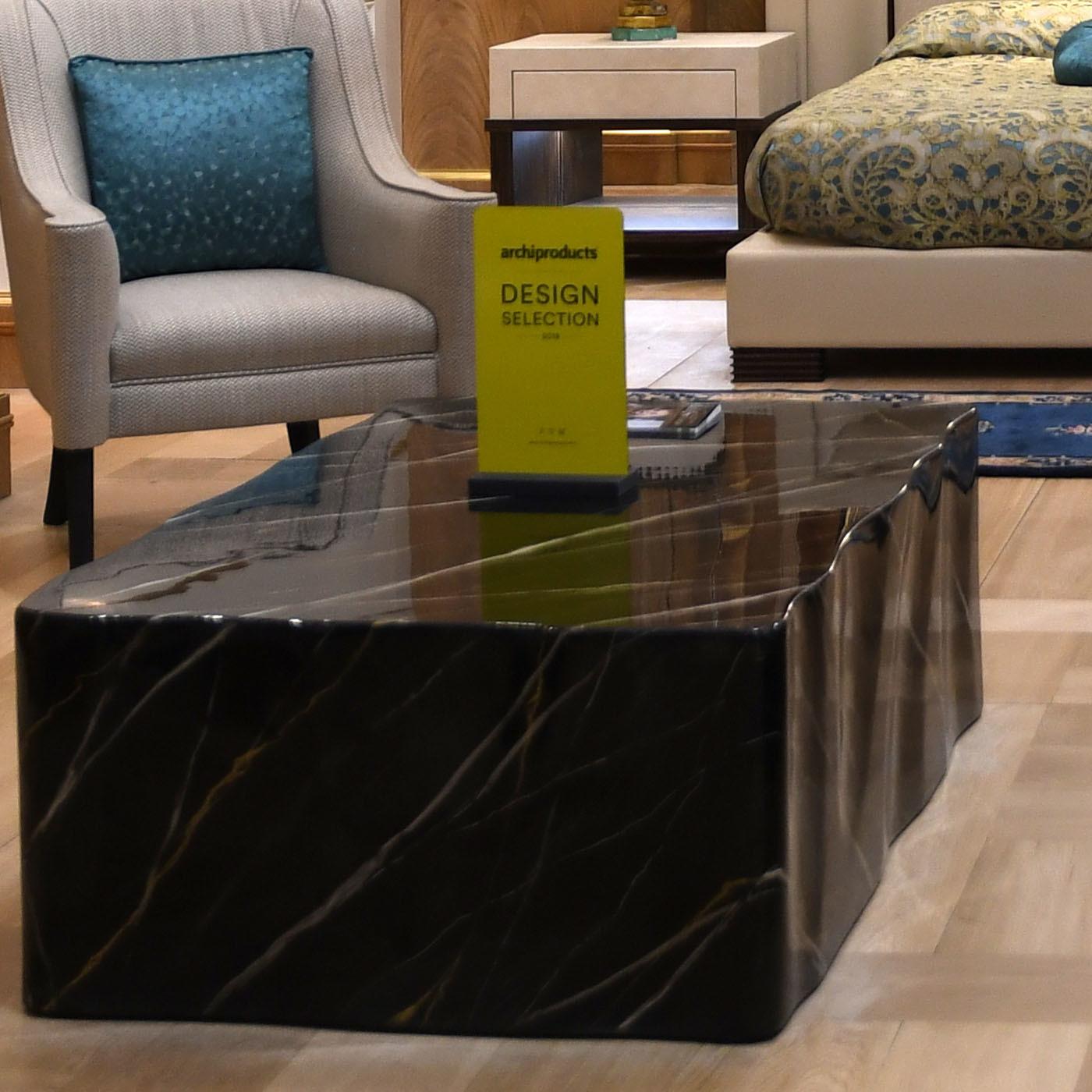 Distinguished by meticulous attention to detail and masterful craftsmanship, this coffee table is seemingly sculpted from a single solid block of marble. Characterized by a simple yet powerful geometric design, this table is crafted of wood and