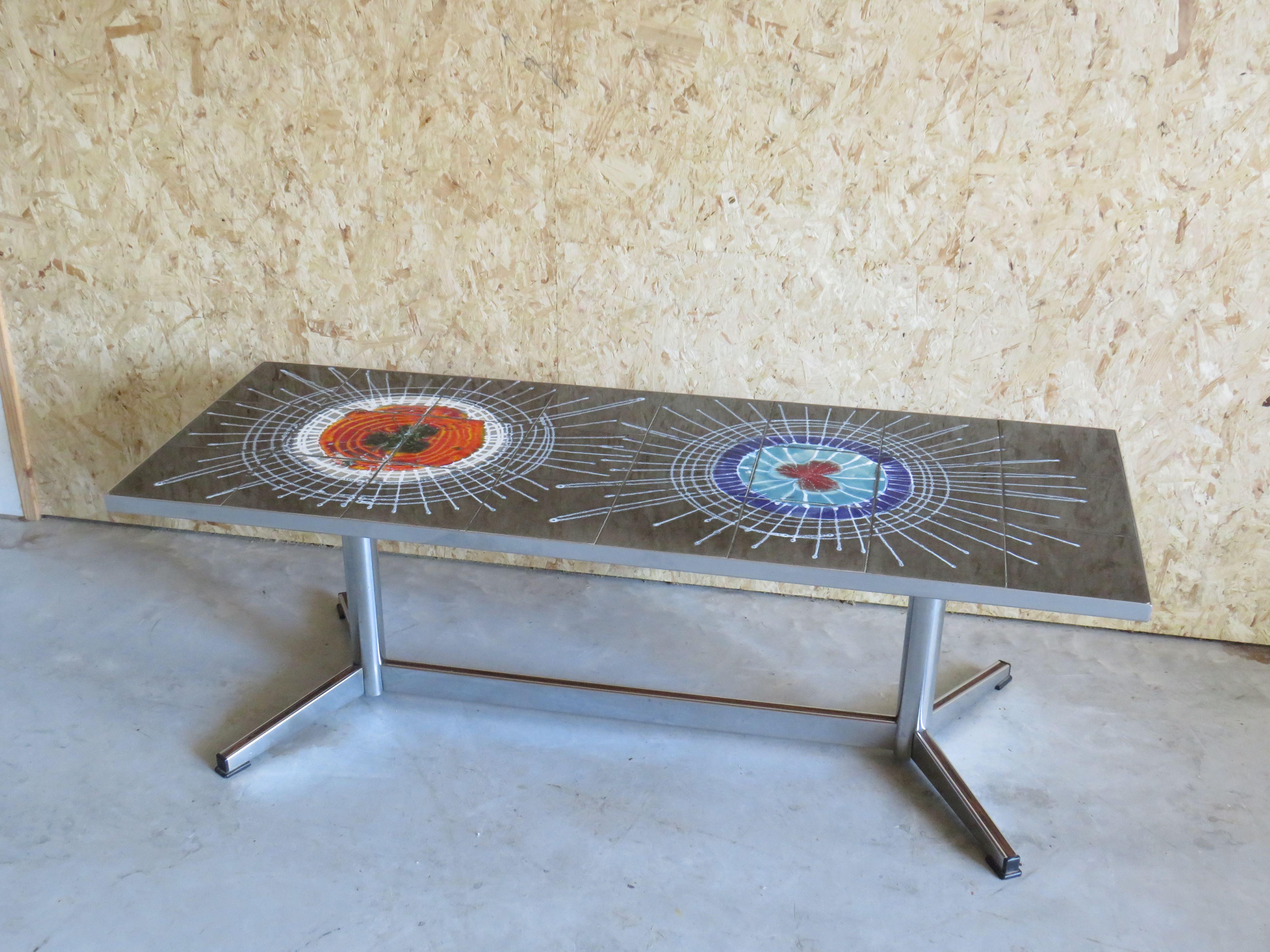 The table has a chromed base with teak (imitation veneer) finish.
The top of the table has ceramic tiles with a beautiful abstract floral pattern, characteristic of Belarti's designs.

