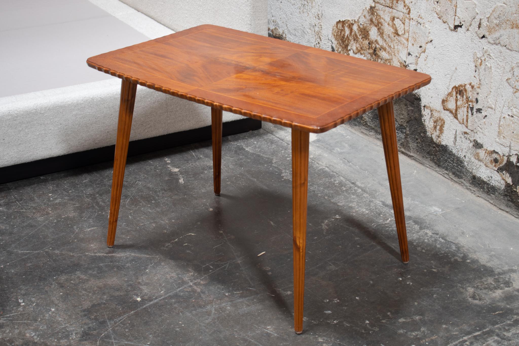 Midcentury Swedish coffee table made of crotch mahogany. Beautiful fluted tabletop edge and reeded legs. Would also work well as a side or end table.