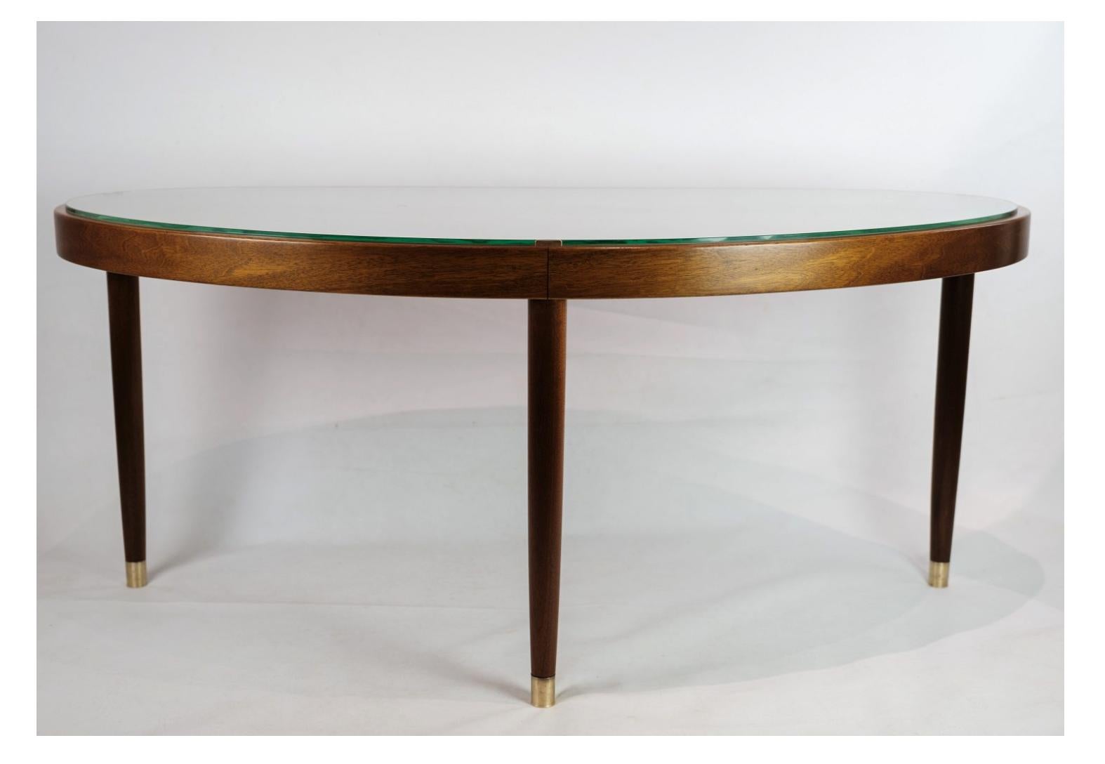 The coffee table, featuring a glass top and a walnut base, crafted by a Danish master carpenter in the 1940s, is a timeless piece of furniture that epitomizes the elegance and craftsmanship of mid-century Danish design.

The glass top lends a sleek