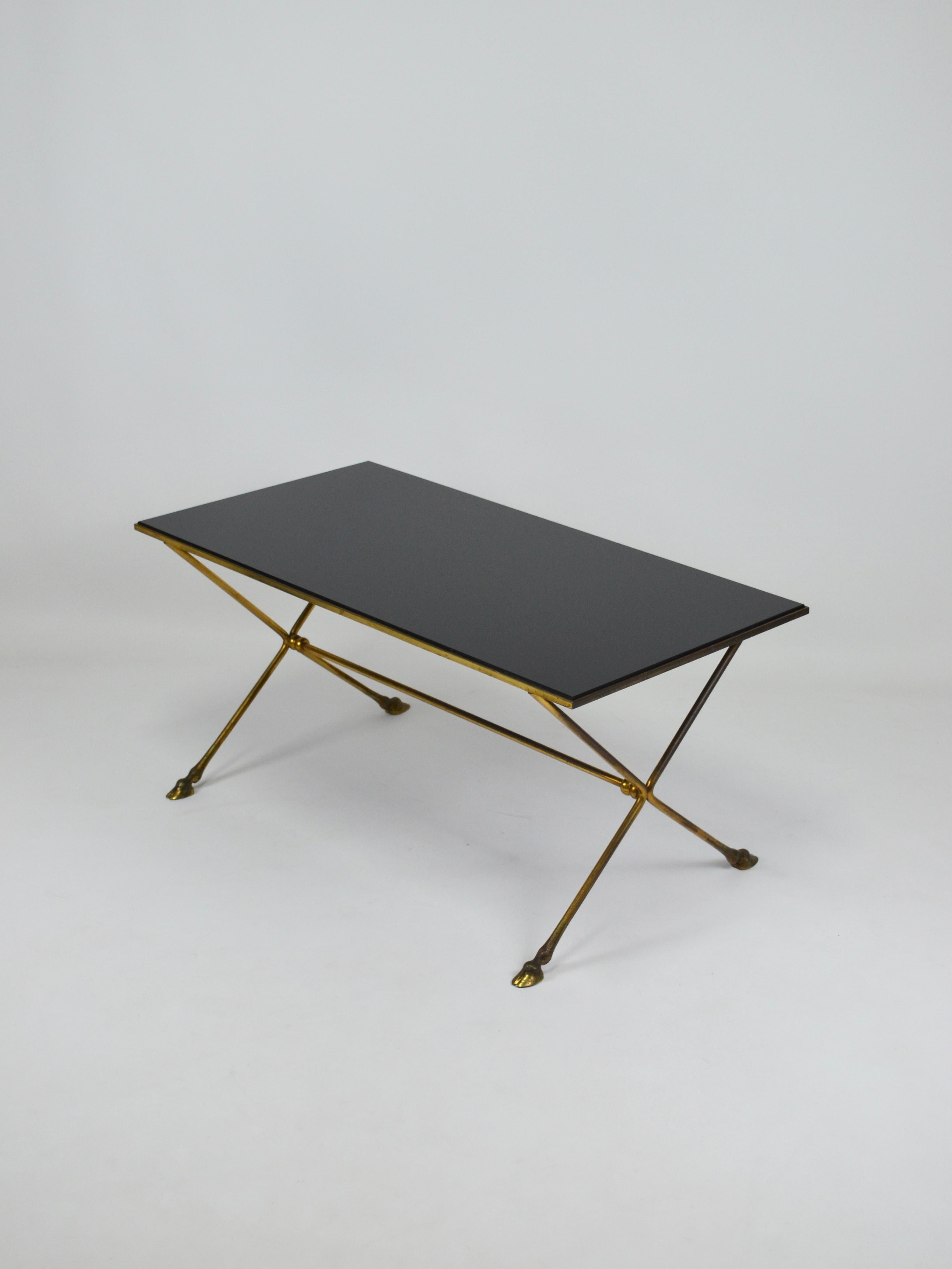 Elegant neo-classical table from the 60's in gilded brass attributed to Maison JANSEN with hoof-shaped legs and bevelled top in glass.
Base with round X-shaped legs with intermediate spacer.