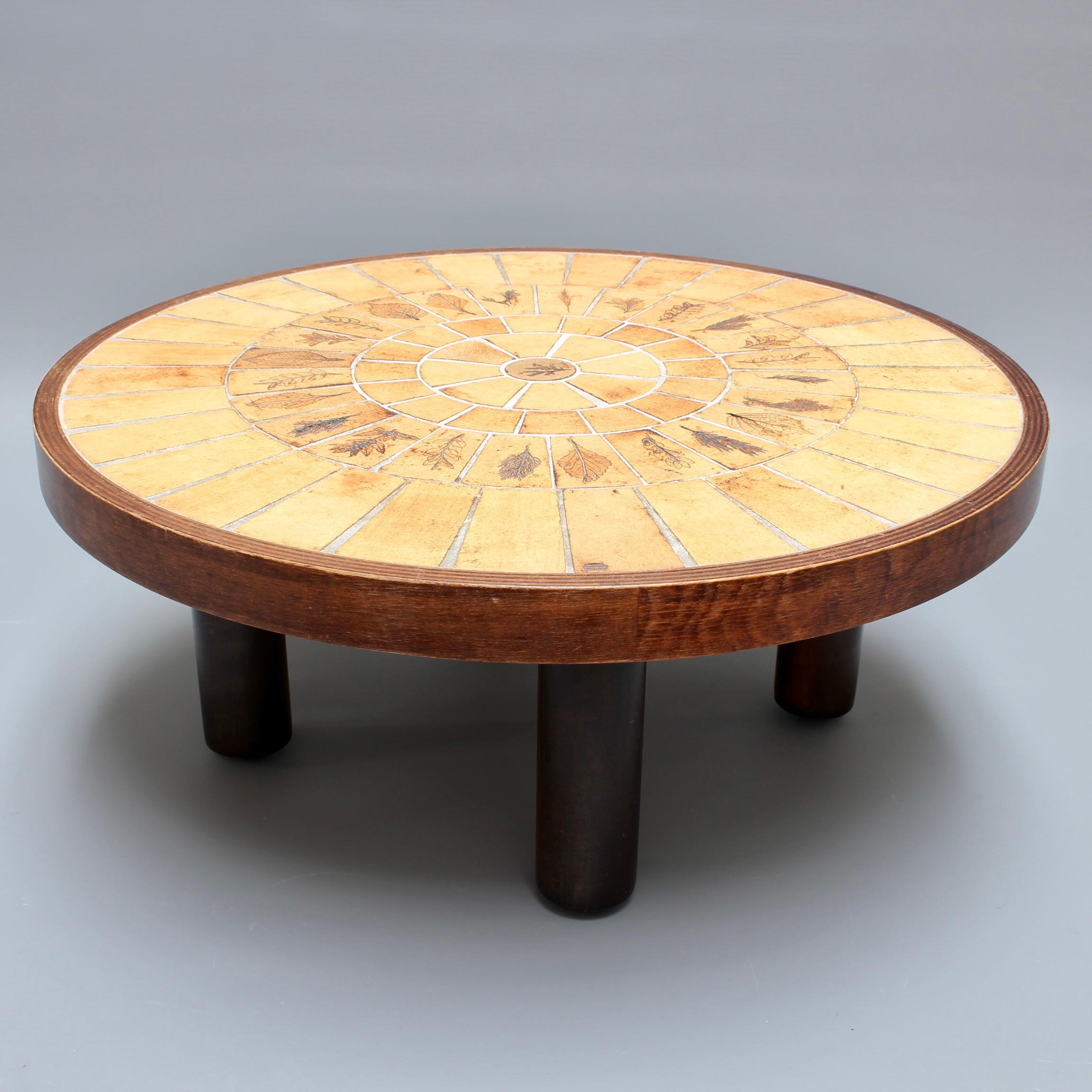 Coffee table with leaf motif earthenware tiles by Roger Capron (circa 1970s). This charming round table is a quintessential example of collectible Capron. There are nature-themed tiles with a variety of beautiful leaves impressed into the
