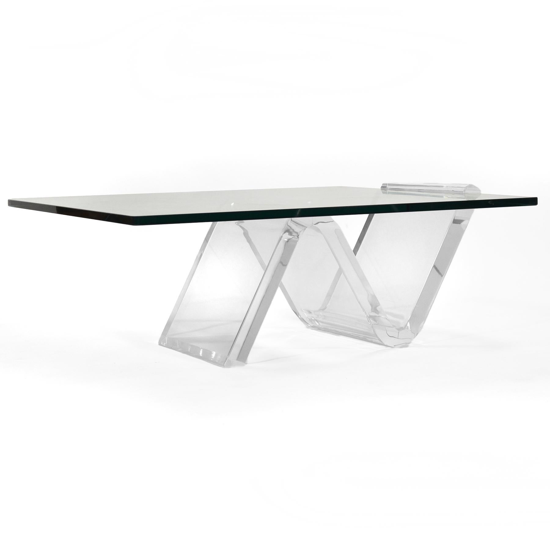 Cette table basse, au design ravissant et spectaculaire, présente un plateau en verre épais intelligemment soutenu et maintenu par la base sculpturale en Lucite en forme de zigzag.
