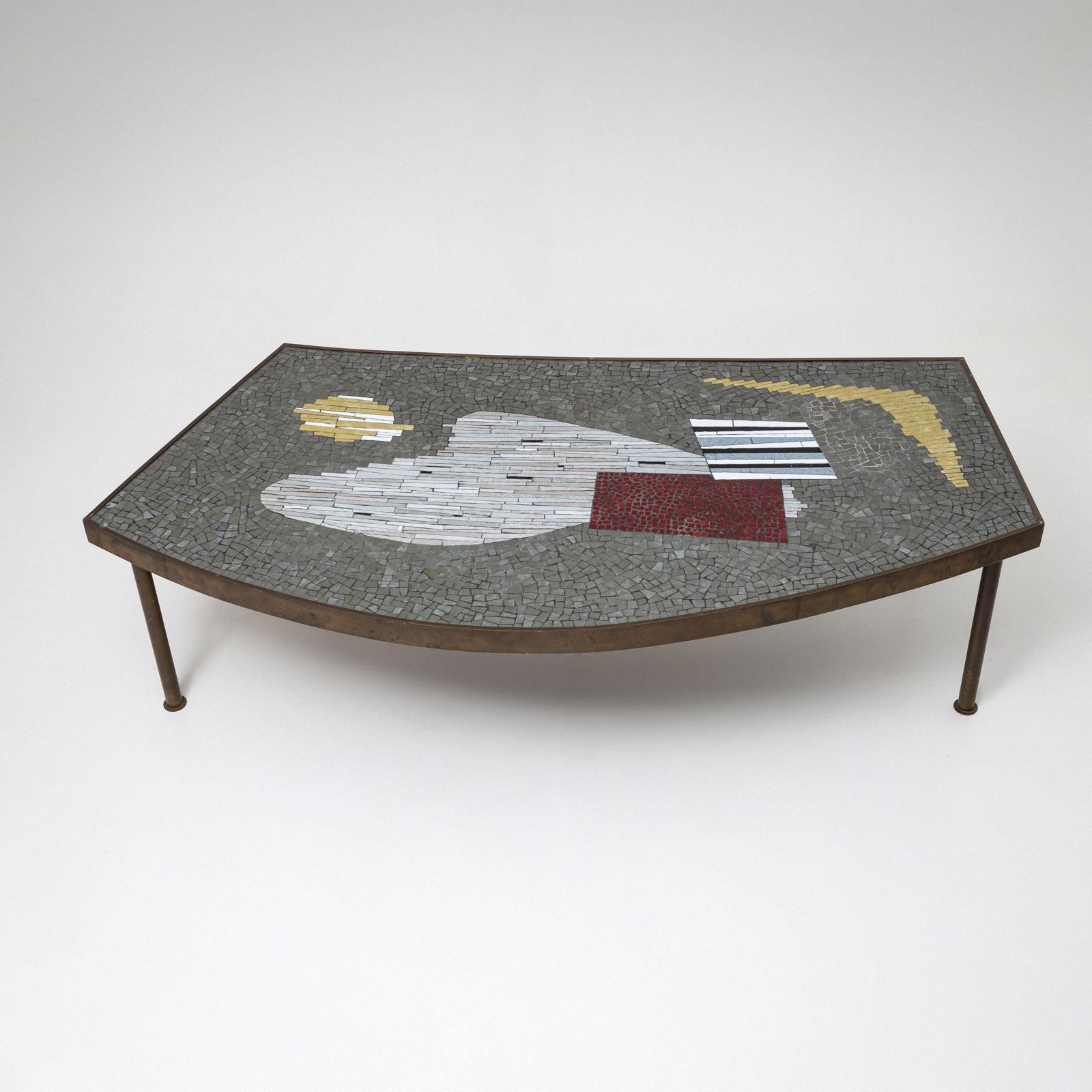 Table basse contemporaine de Berthold Müller-Oerlinghausen, fabriquée au milieu du XXe siècle. La table est dotée de pieds métalliques fins et ronds et d'un plateau trapézoïdal arrondi. Le plateau est décoré d'une mosaïque de pierres grises, beiges
