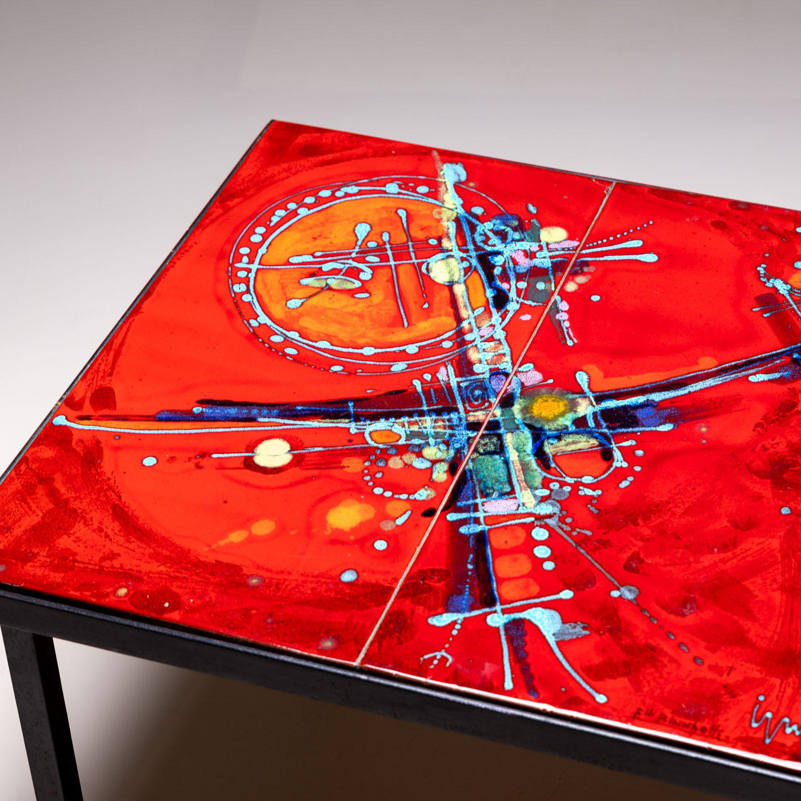 Table d'appoint carrée sur une structure en fer noir et carreaux de céramique émaillée rouge à décor polychrome abstrait. Les carreaux sont signés Ellis Bianchetti.