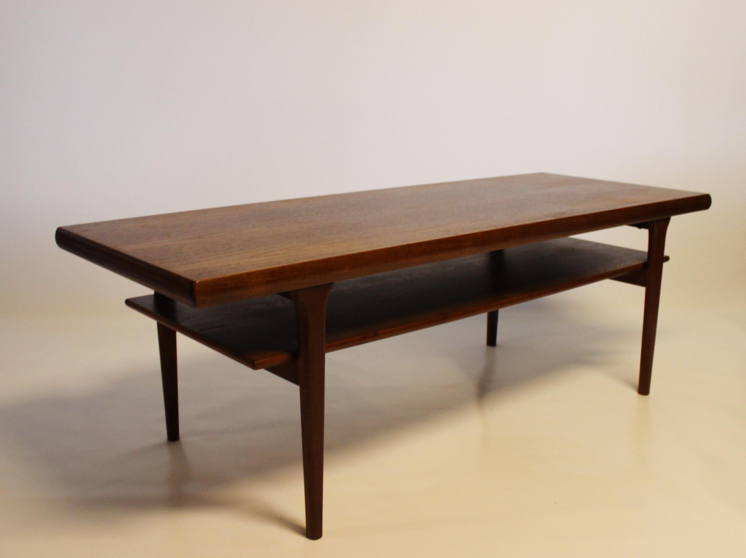Elegant Coffee Table with Shelf: A stunning exemplar of Danish design from the distinguished 1960s, expertly crafted in teak.

This coffee table stands as an iconic representation of the era's design ethos, characterized by its sleek lines,