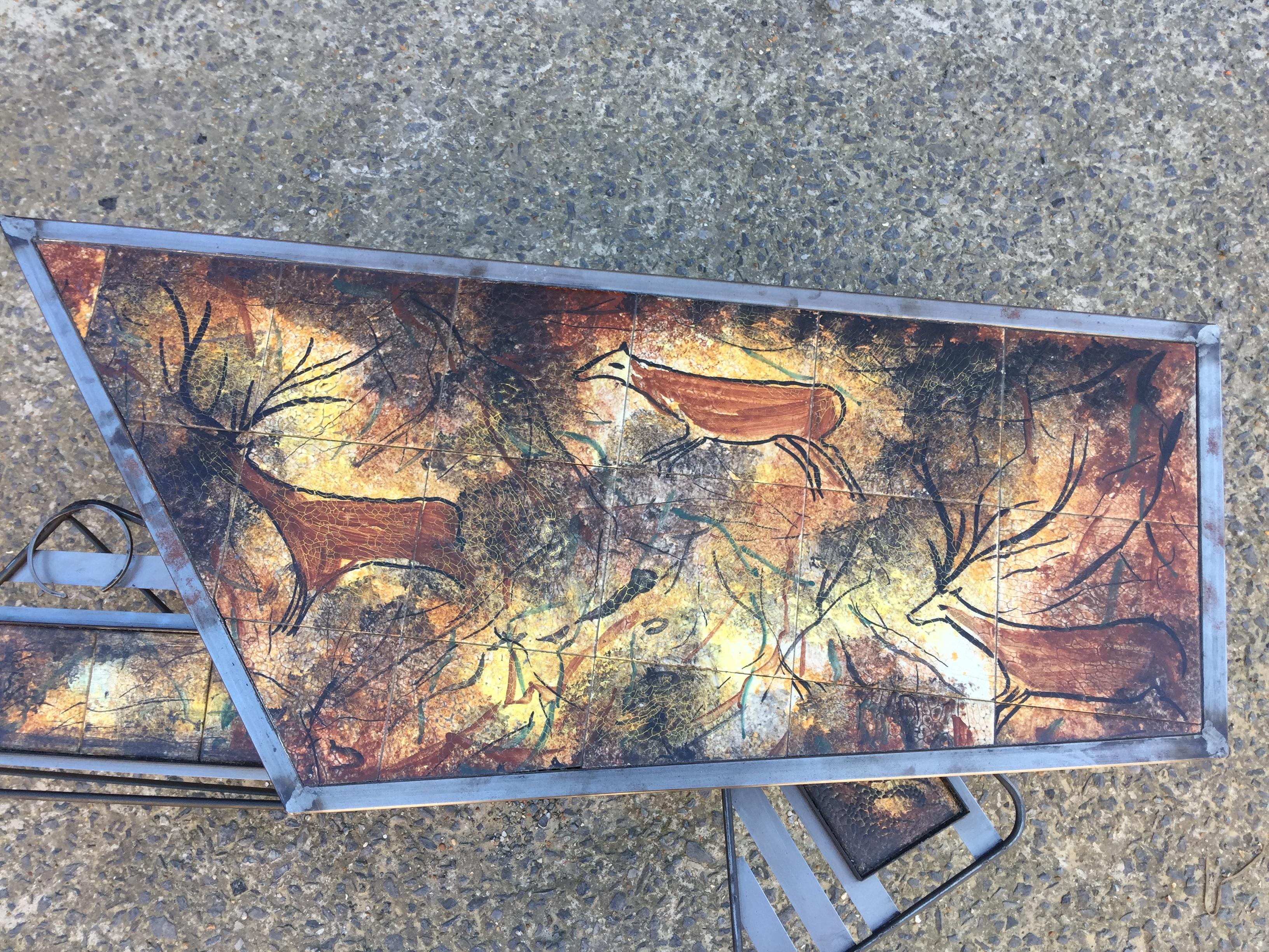 Coffee table with system, circa 1950.
Metal structure, ceramic tiles, two swivel trays.
Decorative prehistoric paintings of 