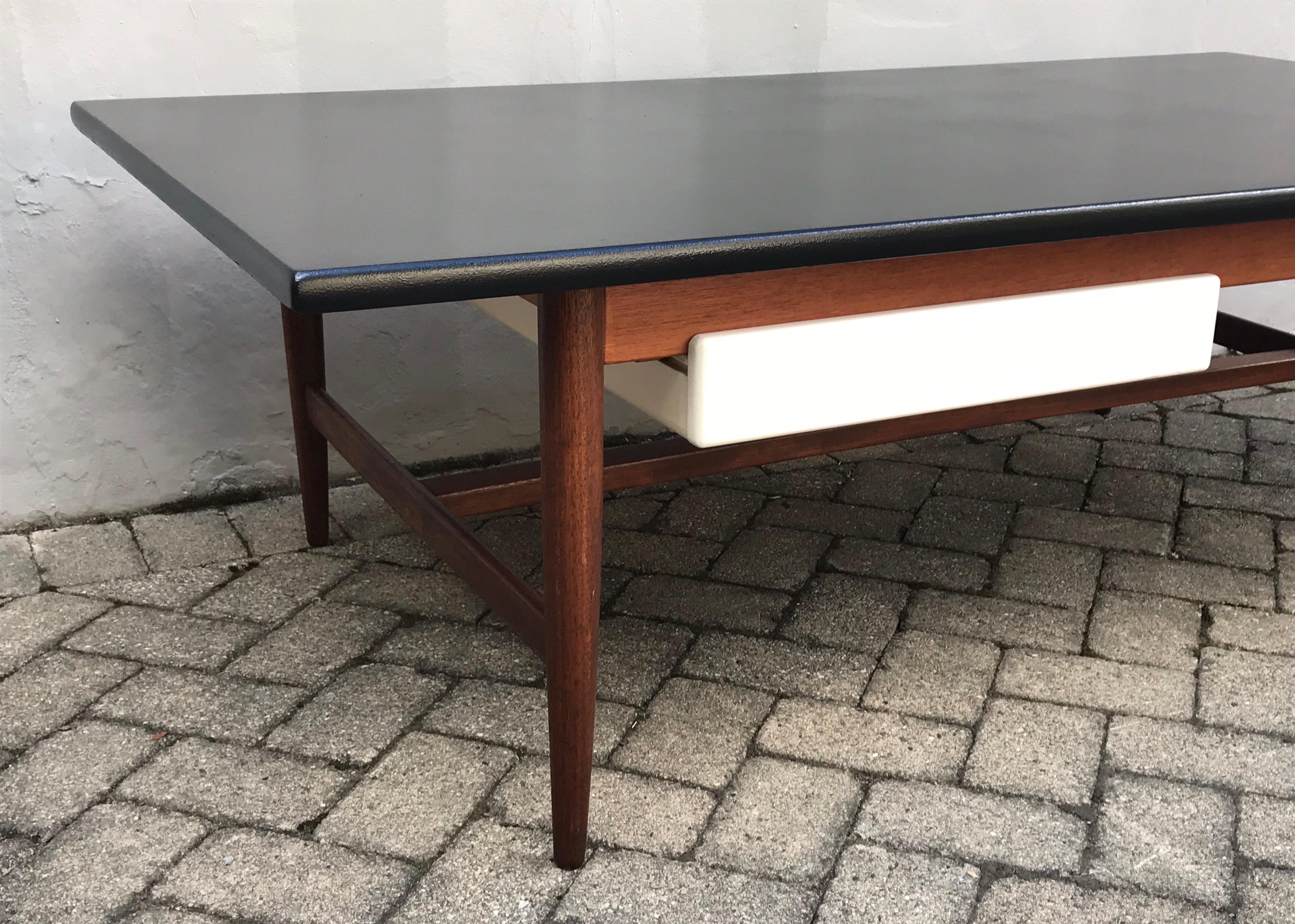 Very nice large scale coffee table made in the Netherlands, 1960s
Solid teak frame with single matte white drawer, rich satin black top.