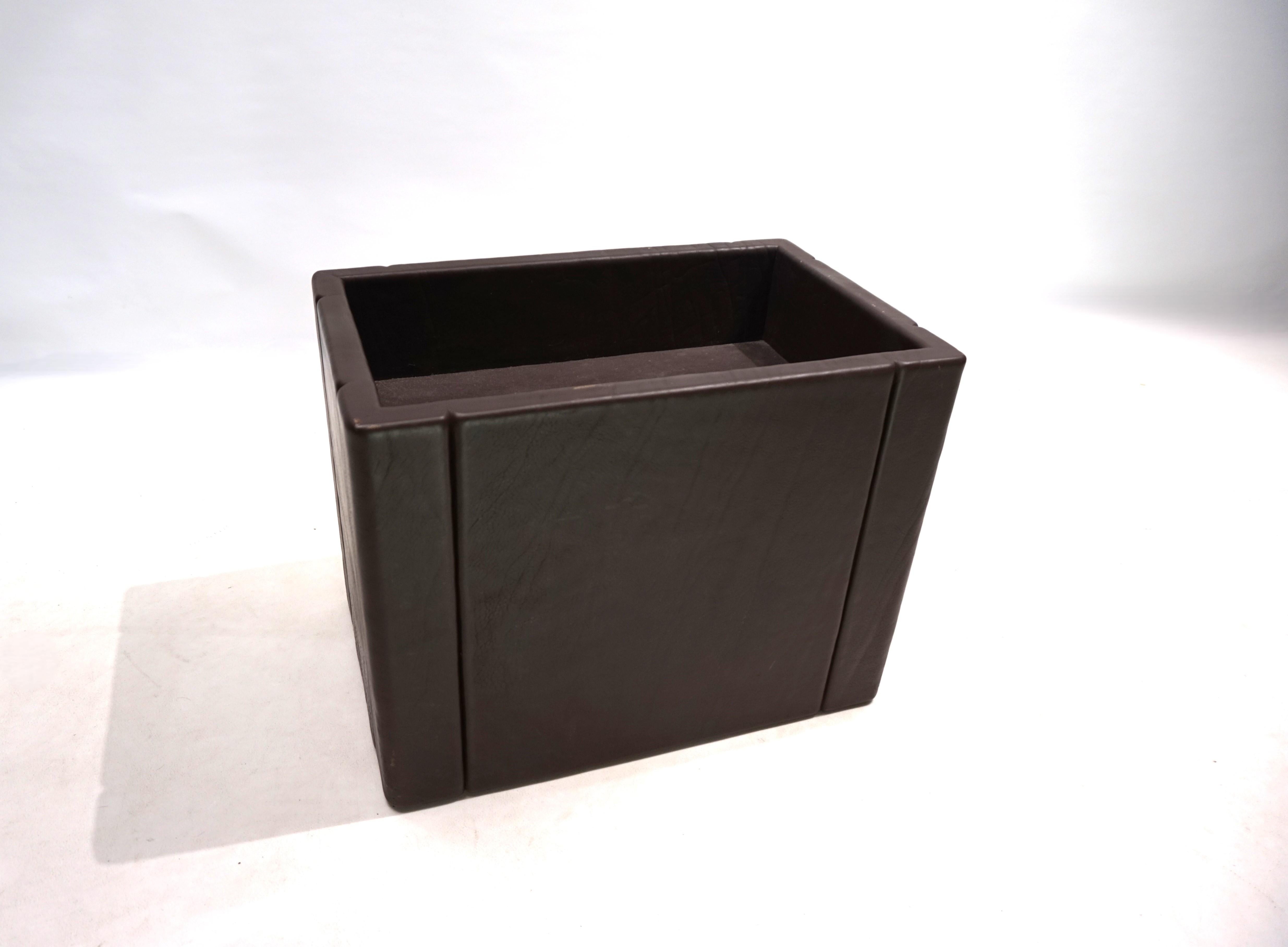 The coffee table features a rectangular brown base, presumably made of faux leather, and is in good condition. Inside, there's a compartment visible through the glass top. The cover is in very good condition, with two optical indentations on each