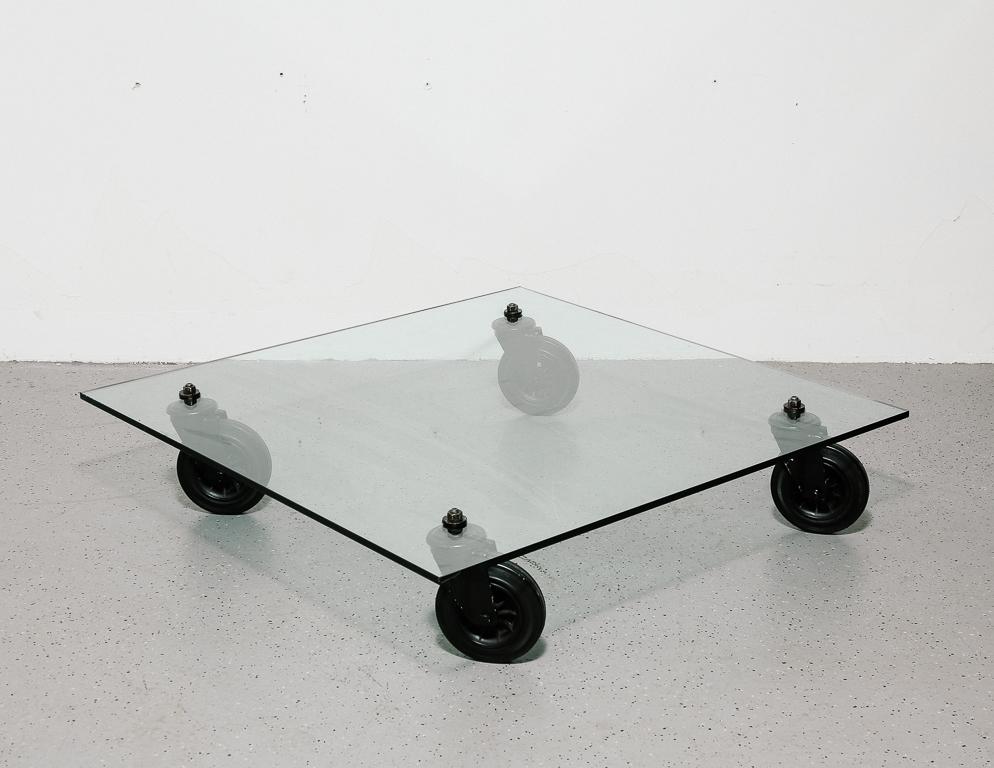 ‘Tavolo con Ruote’ coffee table designed by Gae Aulenti for Fontana Arte, Milan. 15mm glass with huge rubber trolley wheels. Signed by manufacturer on top of glass.
