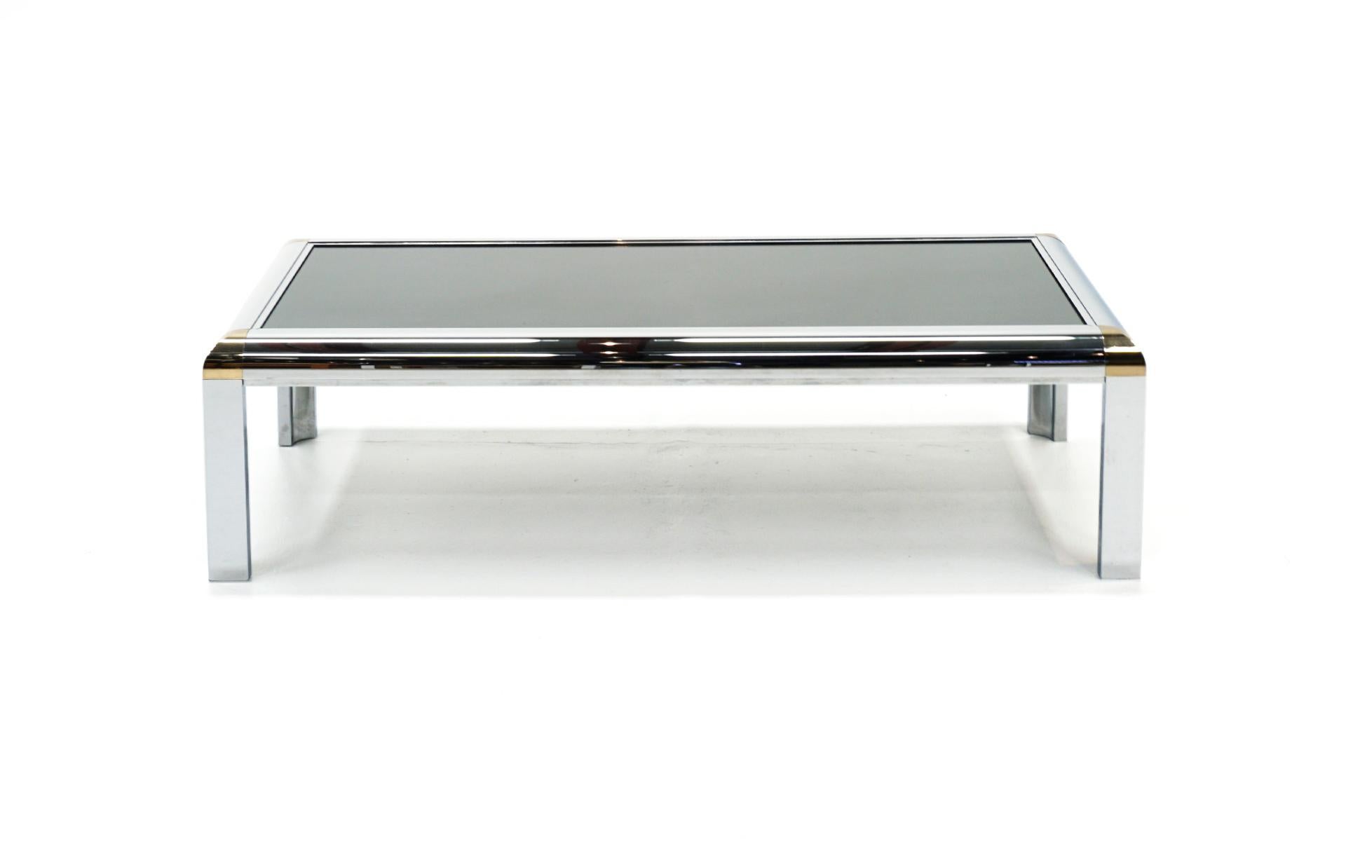 1970s coffee table with wide chrome frame and brass corner accents. Smoked gray / grey glass top. Only very light scratches to the tabletop, no pitting to the chrome. Priced to sell.