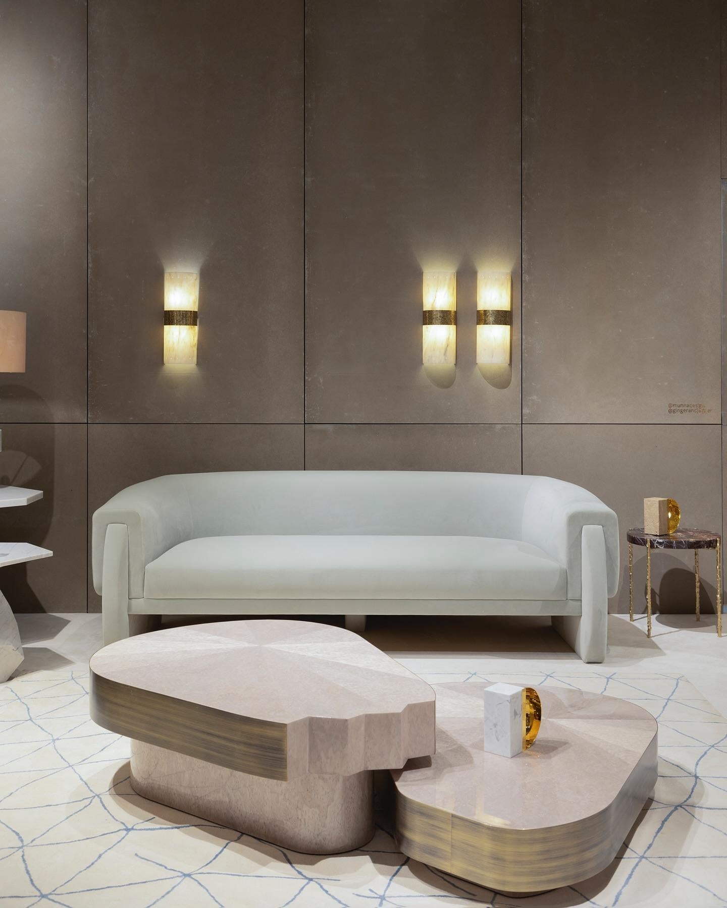 Dieser Couchtisch wurde aus dem Herzen der Bäume geboren, deren konzentrische Ringe die Entwicklung im Laufe der Zeit und den Lauf der Jahreszeiten in jeder Schicht darstellen. Die eleganten Holzfurnieroberflächen, die auf diskreten Sockeln ruhen,