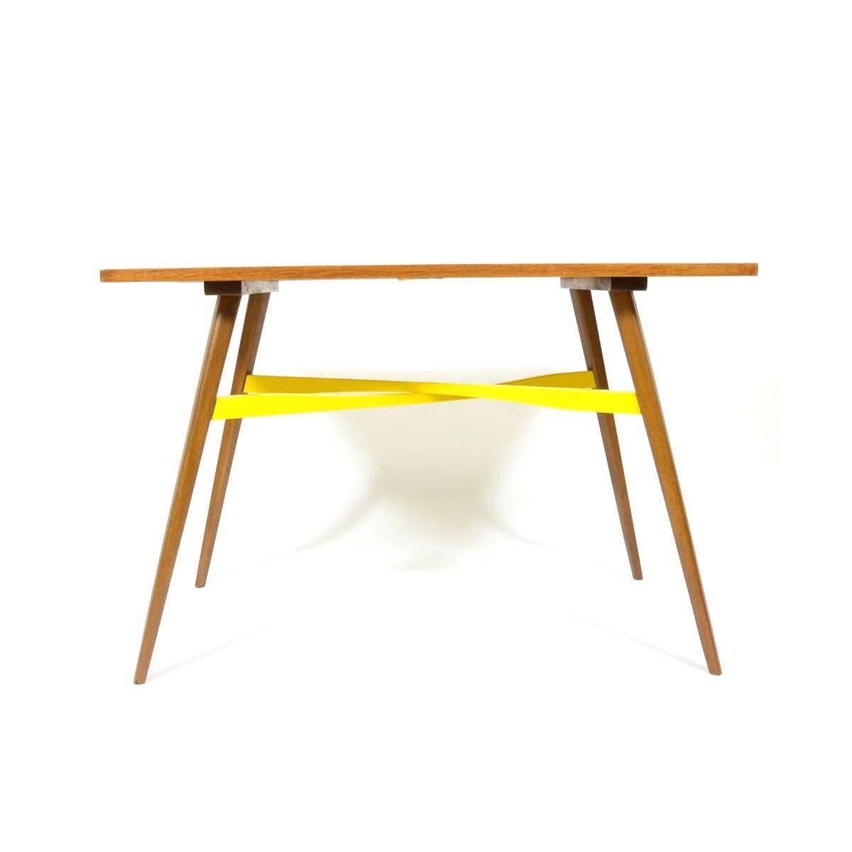 Chic retro coffee table after complete renovation and newly designed yellow varnish on the wooden crossing under table desk, Czechoslovakia, 1970s.