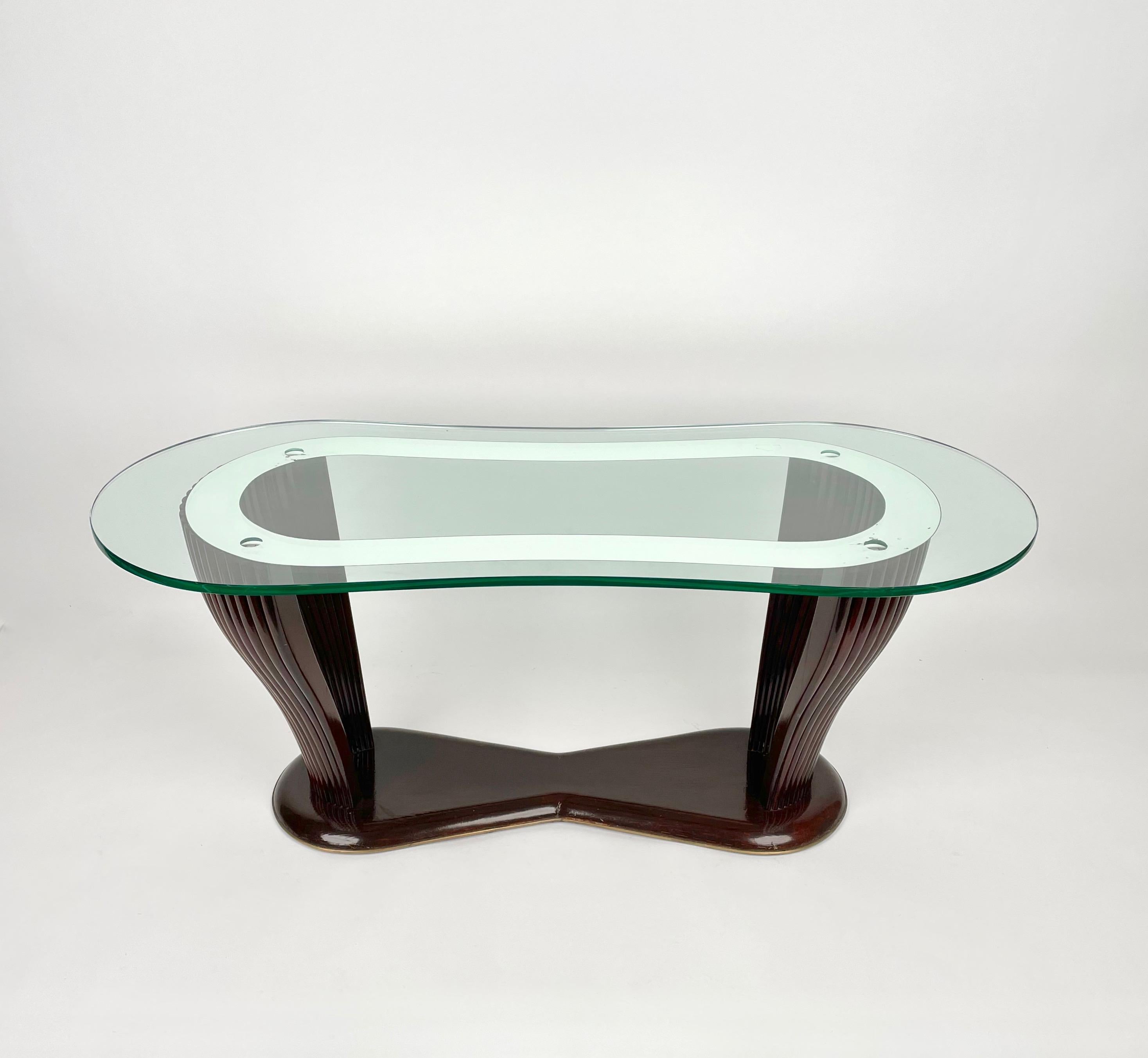 Table basse ovale courbée en structure de bois et verre avec une ligne de miroir encadrée par une bordure en laiton. Fabriqué en Italie dans les années 1950, une collaboration des designers italiens Vittorio Dassi, Santambrogio et De