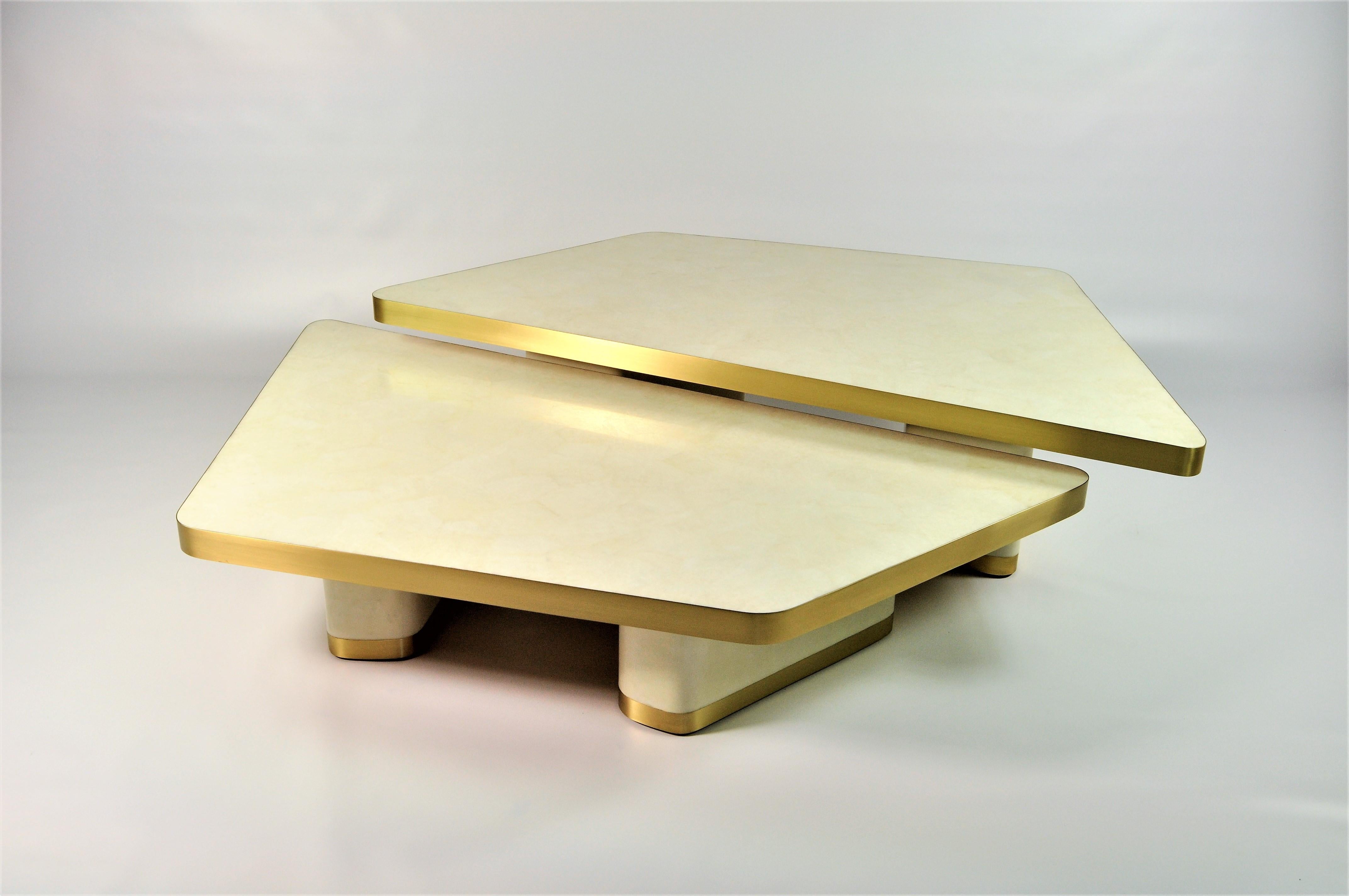 The set of 2 coffee tables VELA is made of various inlaid materials.
These modular tables can be settled up following your wishes.
The top is made of polished rock crystal marquetry with a brushed brass edge. 
The feet are covered with a cream