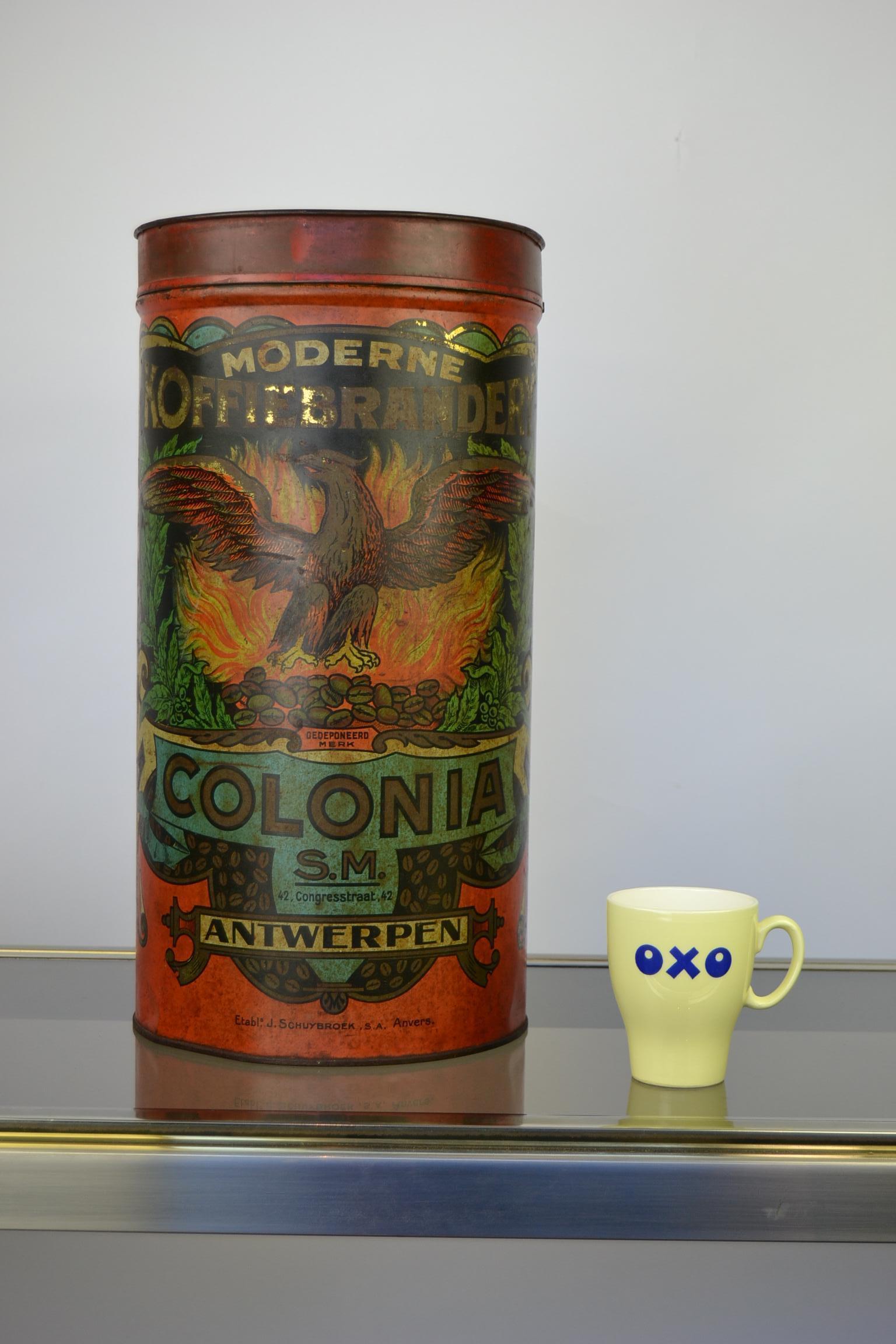 Awesome large coffee tin - coffee tin box from the early 20th century.
This tube shaped red coffee container has a great lithographic design:
An eagle with its wings spread on top of burning coffee beans.
This antique coffee tin was made by