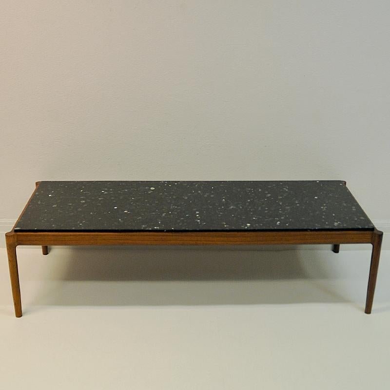 Beautiful midcentury coffee or livingroom table with black anorthosite stone tabletop designed by Ib Kofod Larsen and produced by Säffle Möbelfabrik 1960s. Sweden.
Heavy and massive stone tabletop with nice shimmering stonepatterns and spots in it.