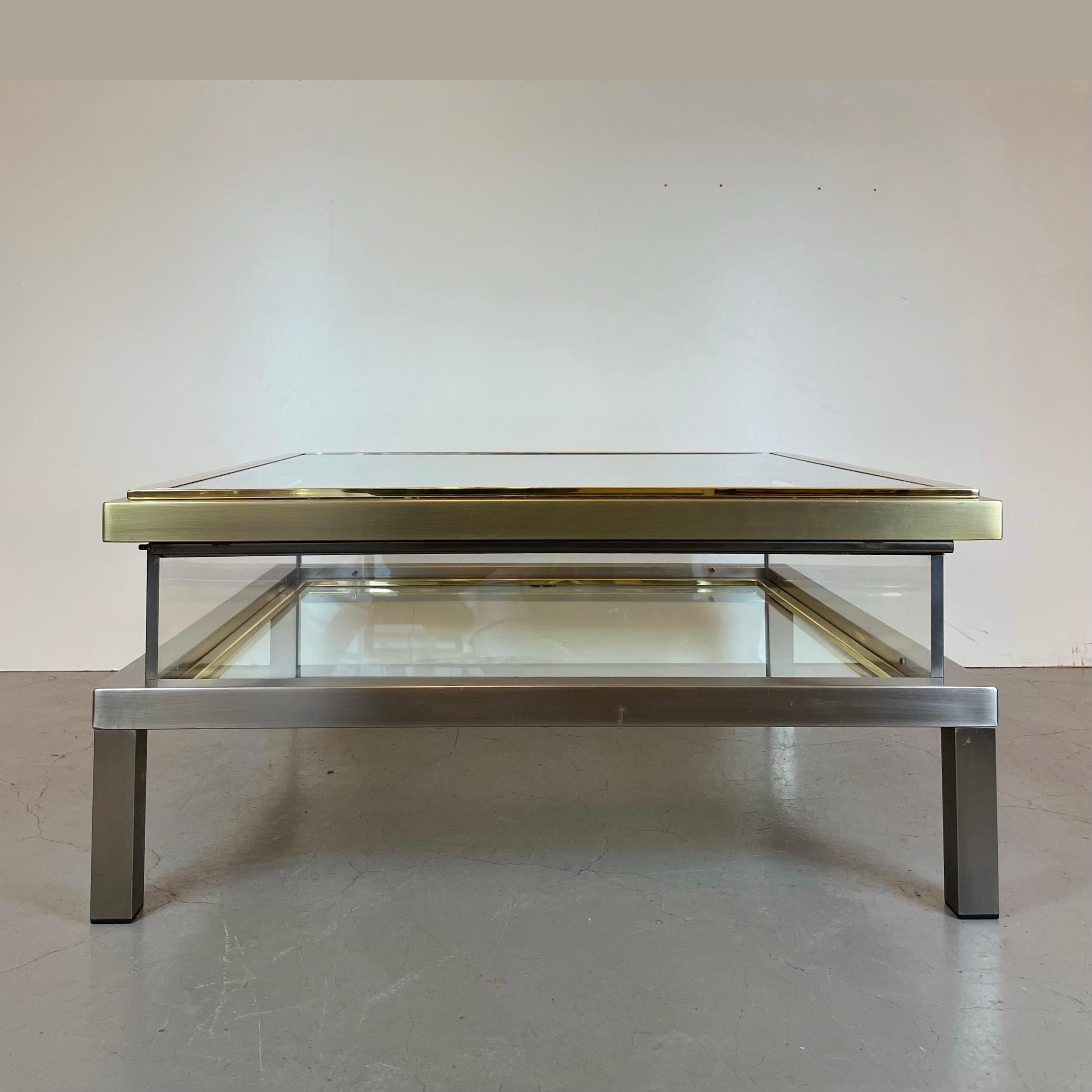 Large square coffee table with a sliding top creating a jewel box-like coffer, all in glass, with a polished steel frame with chrome and brass parts. Drawn by the iconic Belgian brand, Belgo Chrome, in the 1970's.
-
Produced by: Belgo Chrome
Origin: