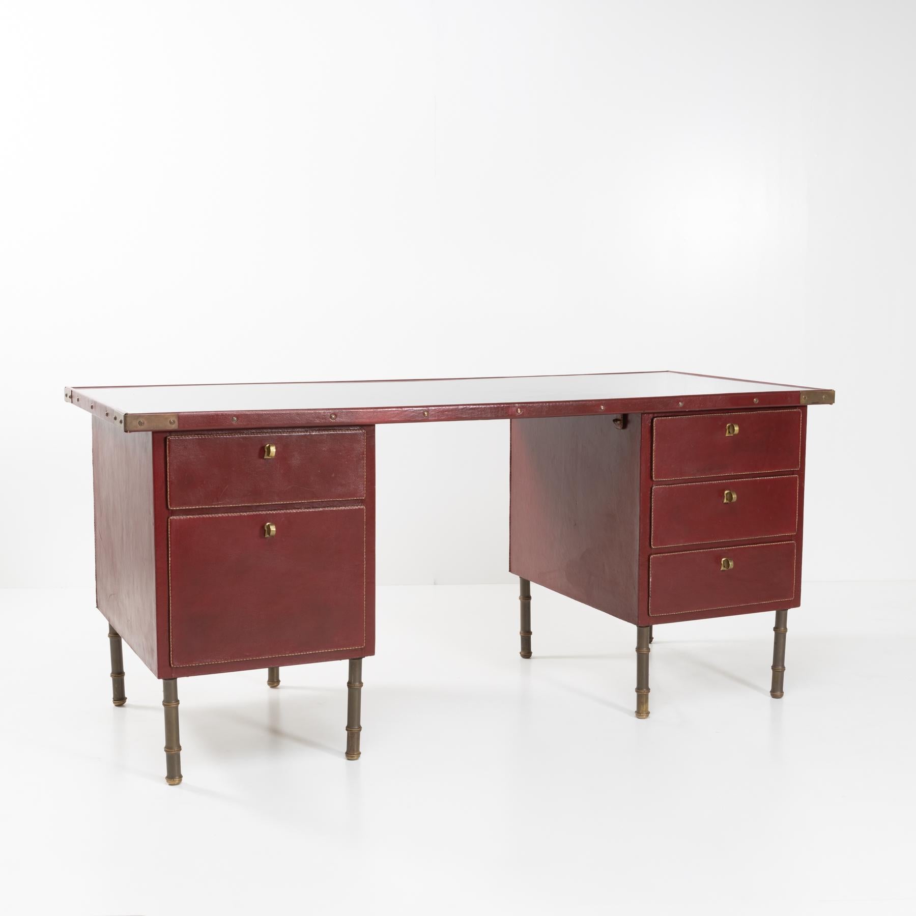 Two coffers desk office in steel and wood fully upholstered in red leather with saddle stitching. 
The right part is equipped of XX drawers, the left is equipped of XX drawers. The drawers have their original keys which allow them to be closed.