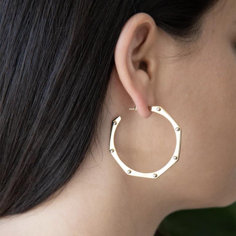 The favorite hoops. Bringing together a classic shape with an industrial touch, this pair of earrings features a round hoop with rivet detailing. 