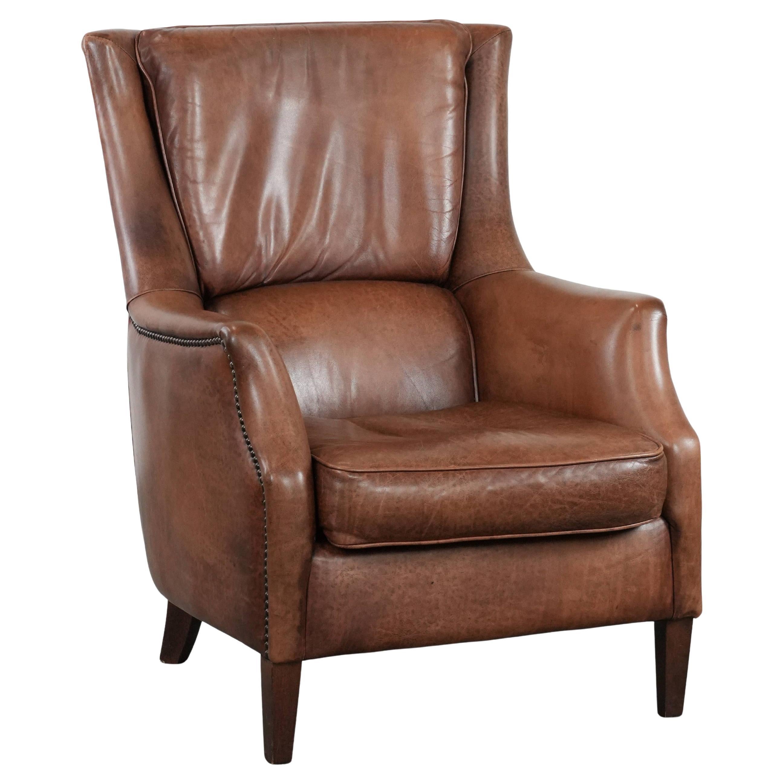 Cognac brown cow leather armchair with decorative nail finish For Sale