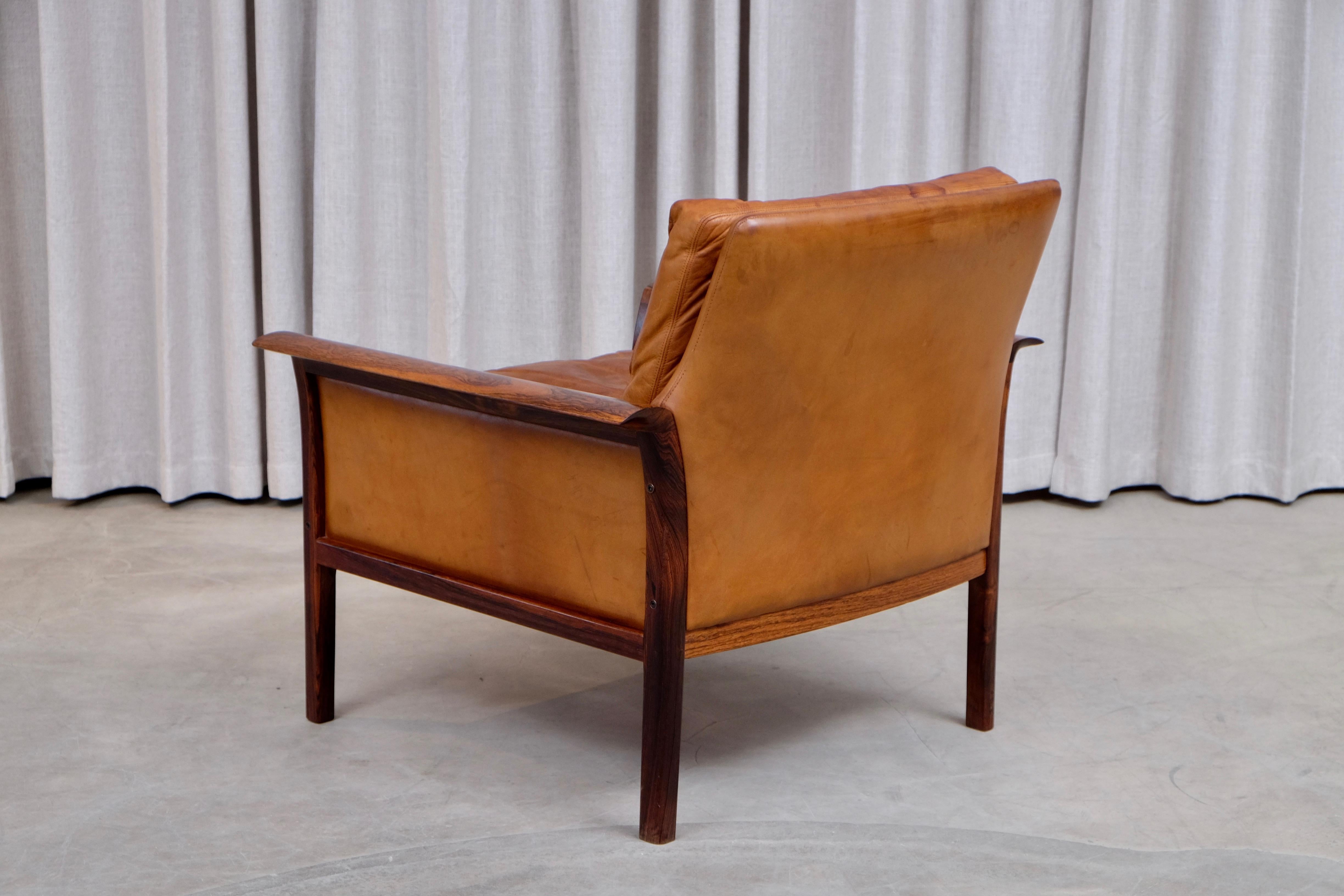 Knut Sæter in collaboration with Fredrik Kayser designed this handsome rosewood lounge chair for Norwegian manufacturer Vatne Møbler. Original cognac brown leather, lovely color.
 